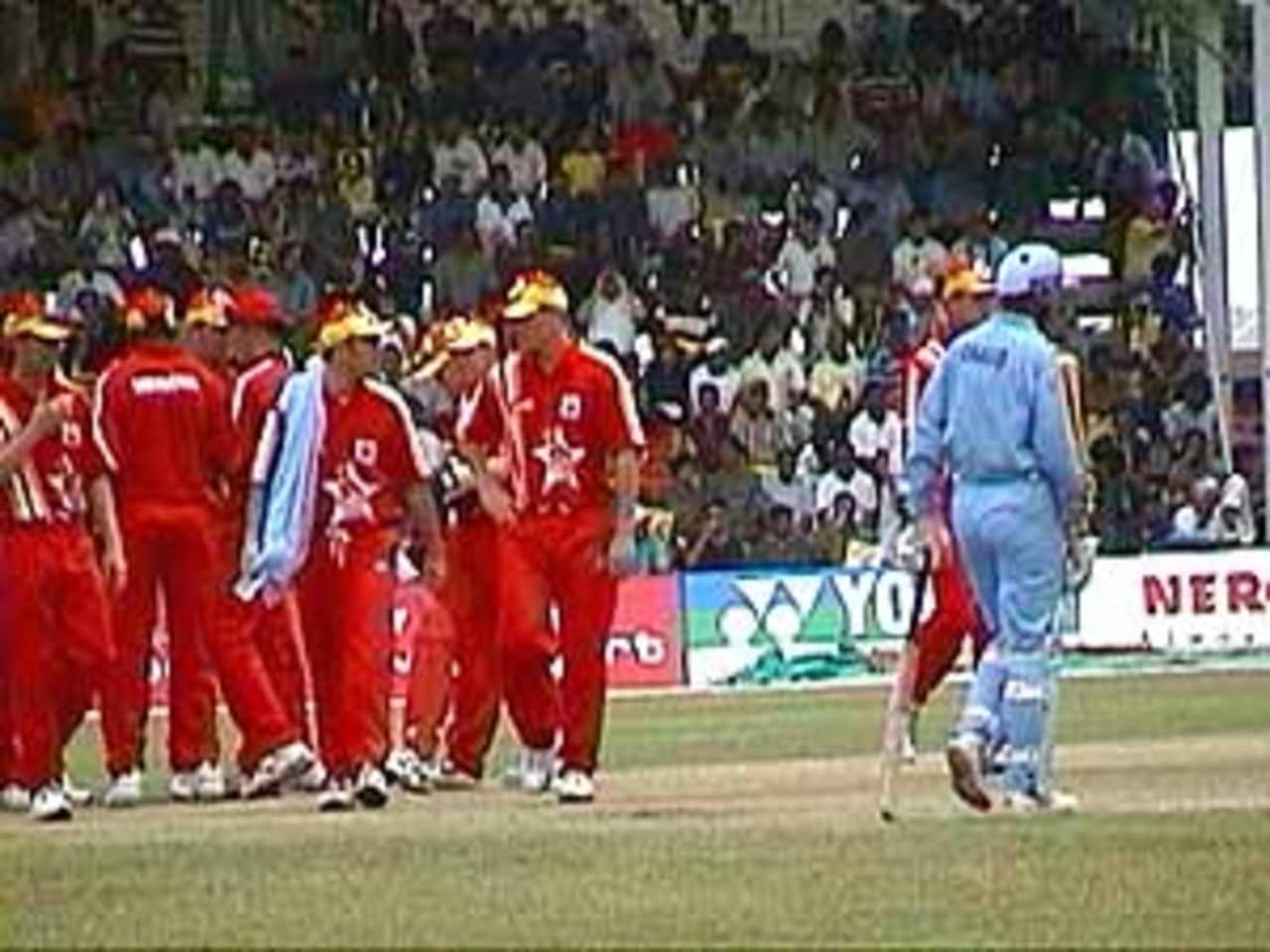 The Zimbabwe team gather around during a drinks break as Dravid waits, India v Zimbabwe (2nd ODI), Coca-Cola Singapore Challenge, 1999-2000, Kallang Ground, Singapore, 4 Sep 1999