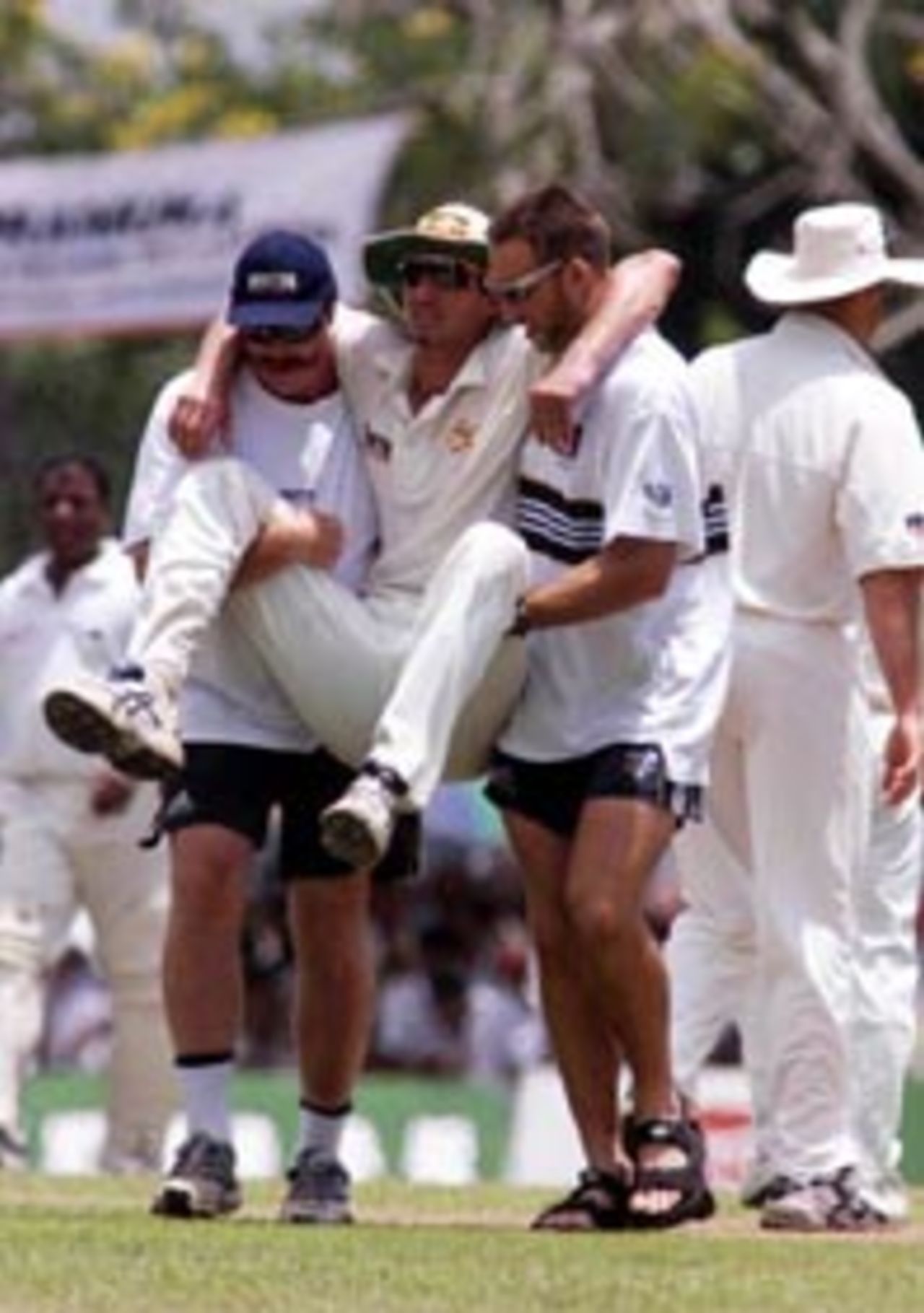 10 Sep 1999: Jason Gillespie leaves the field with assistance from sercurity manager Reg Dickason and fitness manager Dave Misson after he and Steve Waugh of Australia collided attempting a catch, during day two of the First Test between Sri Lanka and Australia at Asgiriya Stadium, Kandy, Sri Lanka.