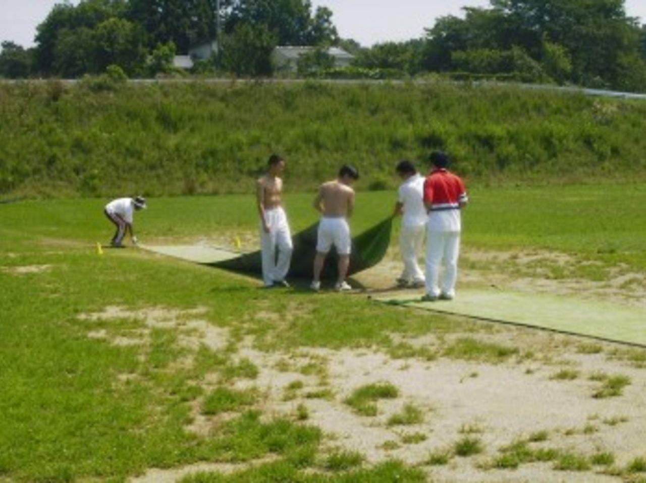 The players "prepare" the wicket for a Gumma League game between Far East and Adolescent Cricket Clubs at Miyagi Mura in Japan.