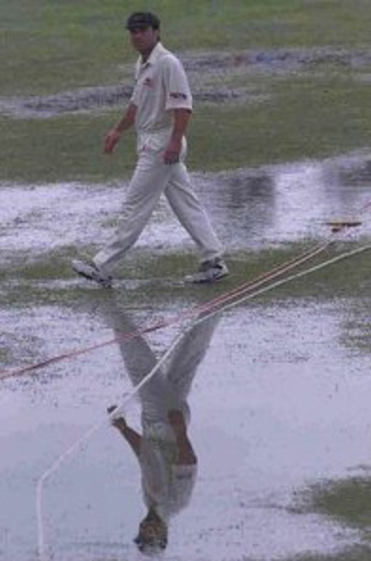 Michael Slater walks among the puddles of water at Galle.