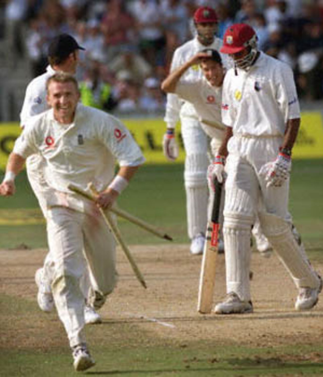 England bowler Dominic Cork (L) runs off the field with the stumps while Nixon McLean (R), of the West Indies dejectedly walks away from the wicket after England won the Fifth Test at the Oval in London. England won the five-match series 3-1 breaking the longest running losing streak in test cricket. The Wisden Trophy, 2000, 5th Test, England v West Indies, Kennington Oval, London, 31Aug-04Sep 2000 (Day 5).