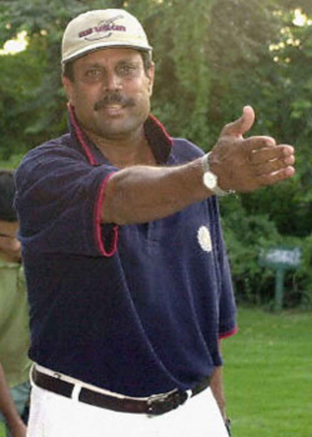 Indian cricketing legend Kapil Dev tries to prevents photographers from shooting him at a golf club in New Delhi after he resigned as the Indian cricket team coach 12 September 2000. Dev, who is in the centre of a match-fixing and corruption probe, had earlier said 'he is clean, but finished with cricket' . Dev had led India to victory in the 1983 World Cup in England and has played 225 one-dayers, scoring 3783 runs and claiming 253 wickets.