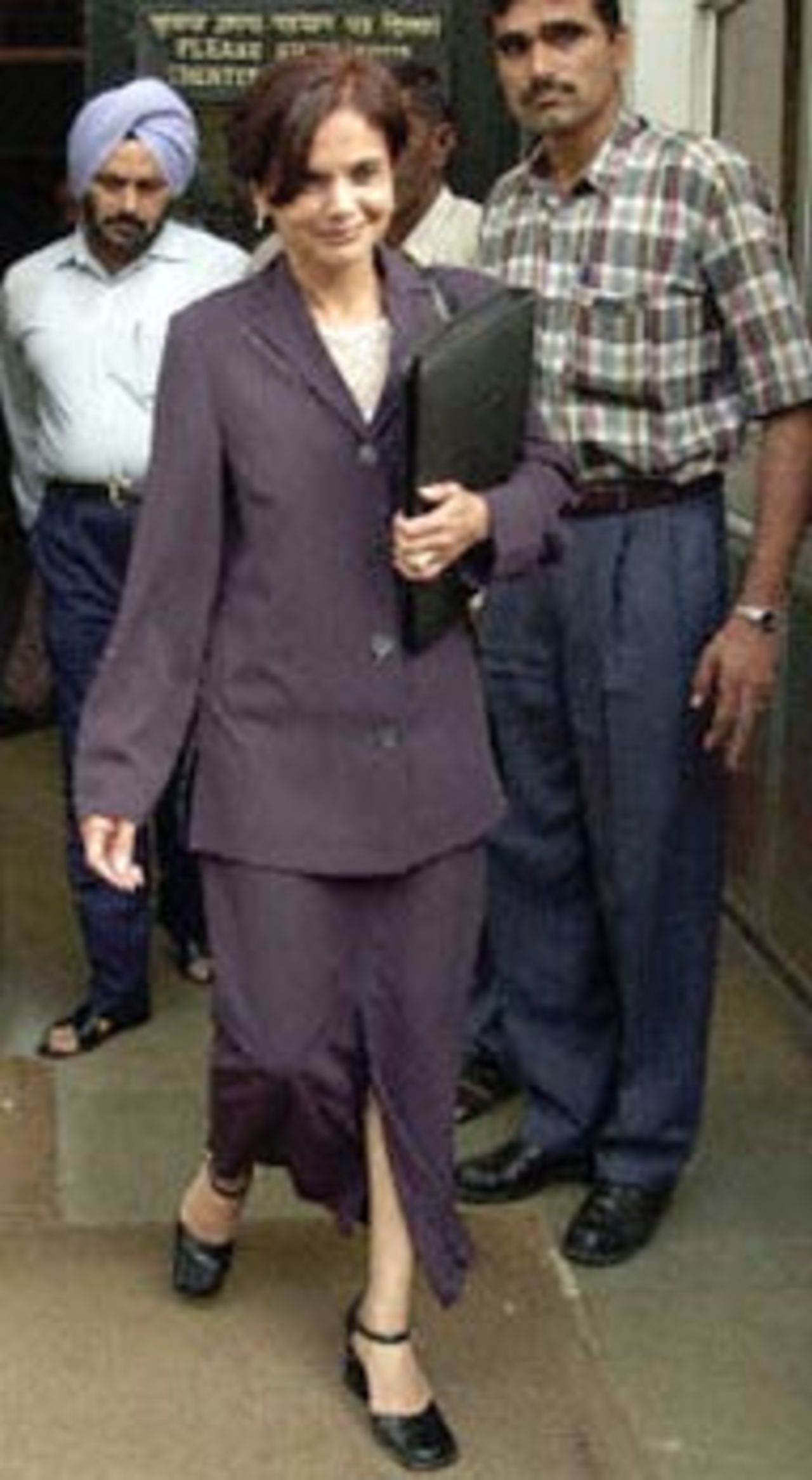 Shamila Batohi (C), South Africa's chief prosecutor in the King Commission of inquiry into corruption in Cricket, walks out of the Central Bureau of Investigation (CBI) office in New Delhi as bureau officials look on, 20 September 2000. Batohi, said though she didn't manage to get hold of the 'Cronjie tapes' which allegedly details disgraced South African skipper Hansie Cronje's conversations with an Indian bookie, she did get hold of the transcripts from Indian officials.