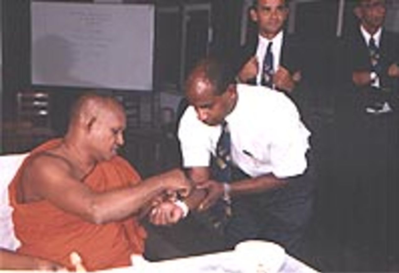 Sanath Jayasuriya  receives blessing from  a Buddhist Monk