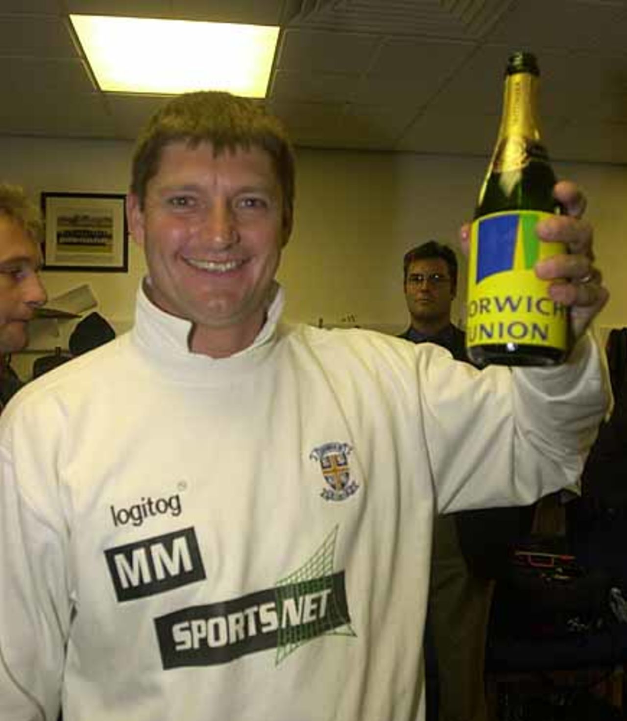 Durham coach Martyn Moxon holds aloft the bubbly after Durham win promotion to Division One of the Norwich Union League