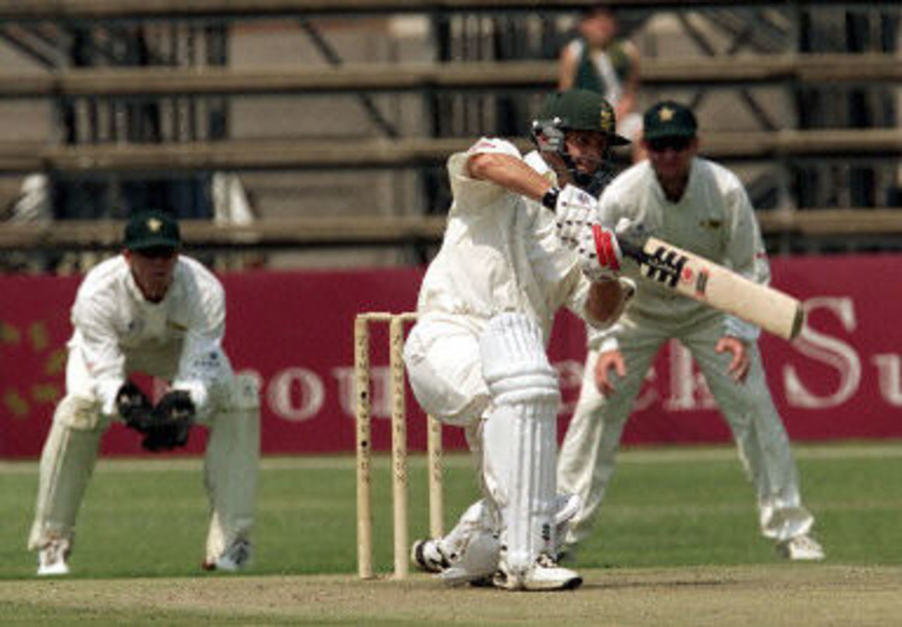 Gary Kirsten drives watched by keeper Andy Flower and Alistair Campbell, Ist Test South Africa v Zimbabwe, 7-11 September 2001, at Harare.