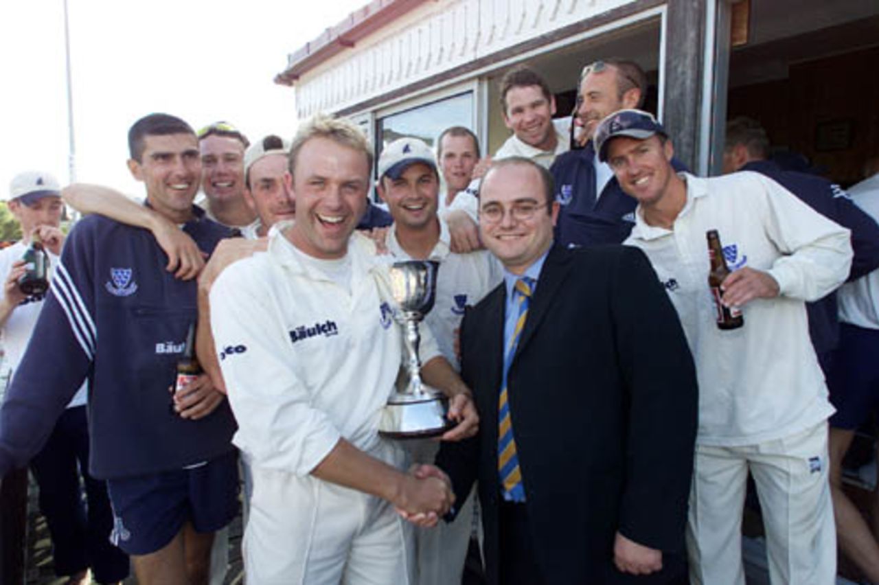 Sussex captain Chris Adams receives the cup from CricInfo's Andrew Hall after winning the second division after the county championship match against Gloucestershire at Hove
