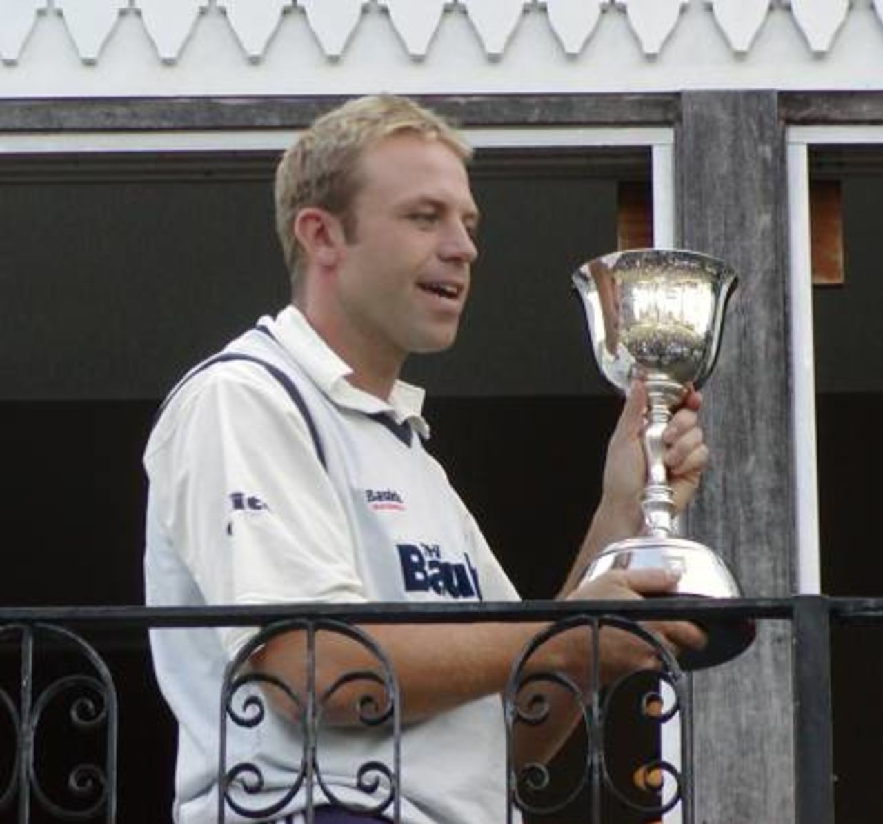 Chris Adams holds the CricInfo 2nd Division Championship trophy aloft