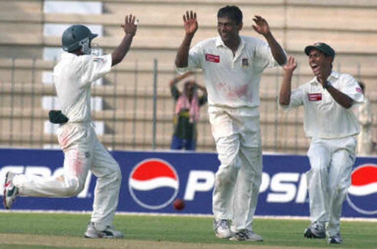 Mohammad Rafique celebrates with teammates Mohammad Ashraful and Alok Kapali, Pakistan v Bangladesh, 3rd Test, Multan, September 4, 2003.