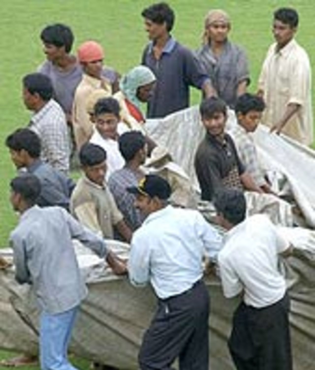 Groundsmen pulling the covers as rain washes out play on the second day, Board President's XI v New Zealand tour match, day two, Visakhapatnam, 270903