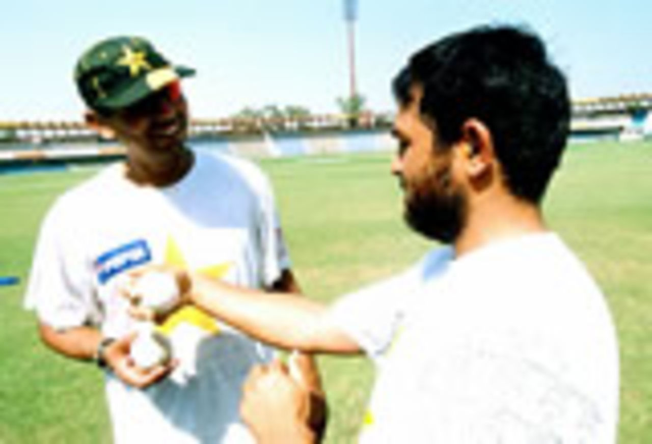 Pakistani spinners Saqlain Mushtaq (L) and Mushtaq Ahmed discuss a bowling plan for the series against South Africa at the Gaddafi Stadium, Monday, September 29, 2003.