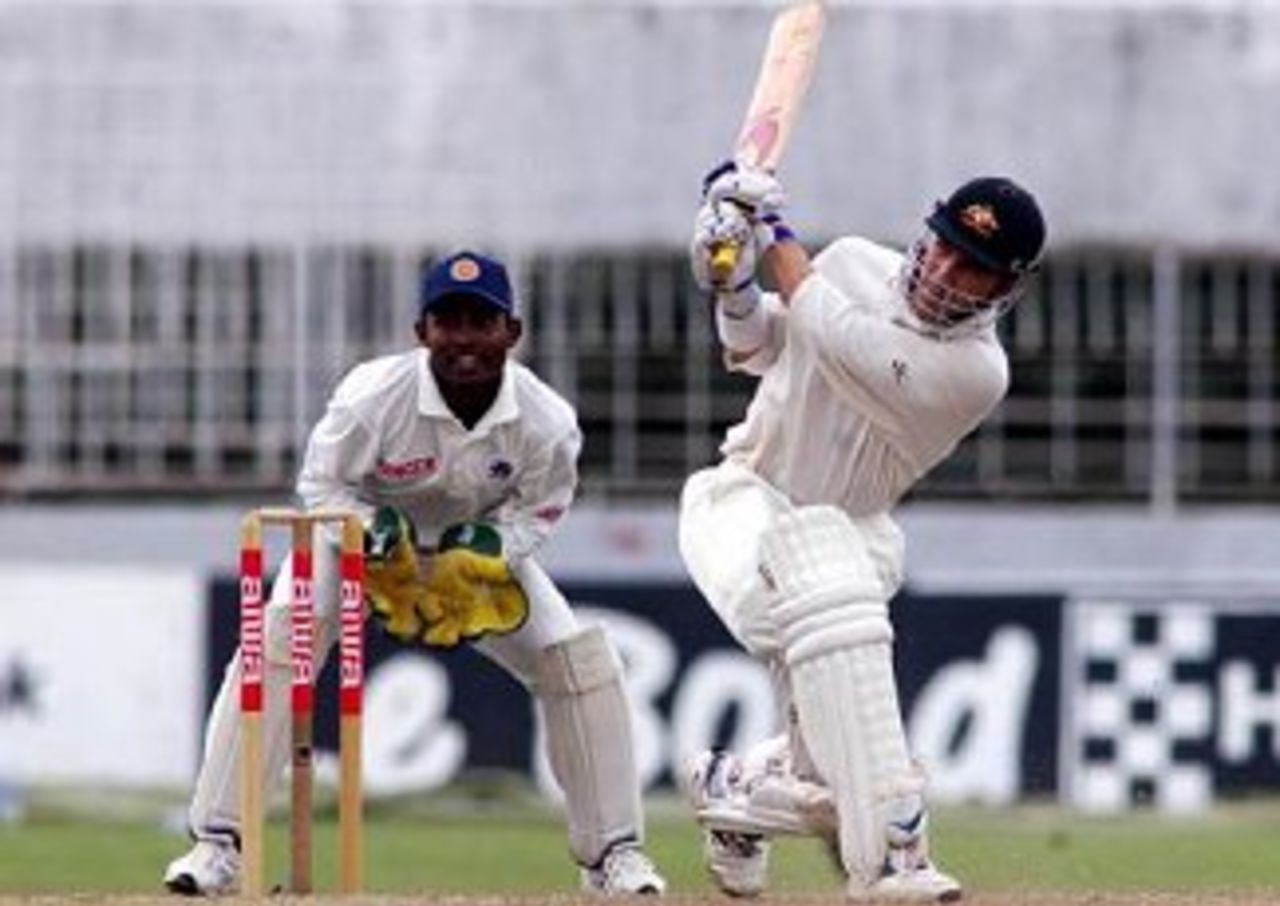 30 Sep 1999: Justin Langer of Australia hits out with Romesh Kaluwitharana of Sri Lanka looking on, on day one of the 3rd Test between Sri Lanka and Australia at Singhalese Sports Club, Colombo, Sri Lanka.