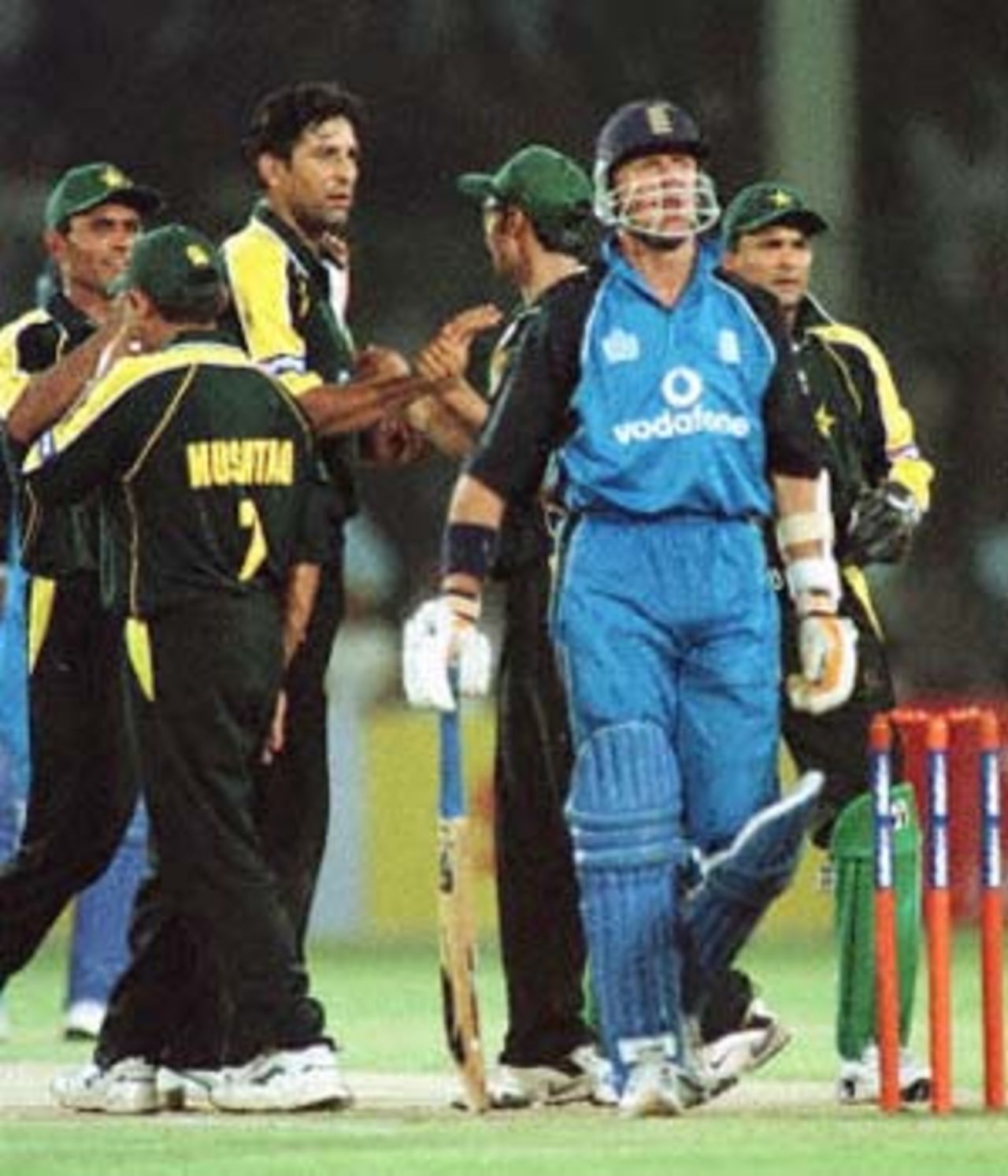 The Pakistan team congratulate Wasim Akram as a disconsolate Alec Stewart walks off, England in Pakistan, 2000/01, 1st One-Day International, Pakistan v England, National Stadium, Karachi, 24 October 2000.