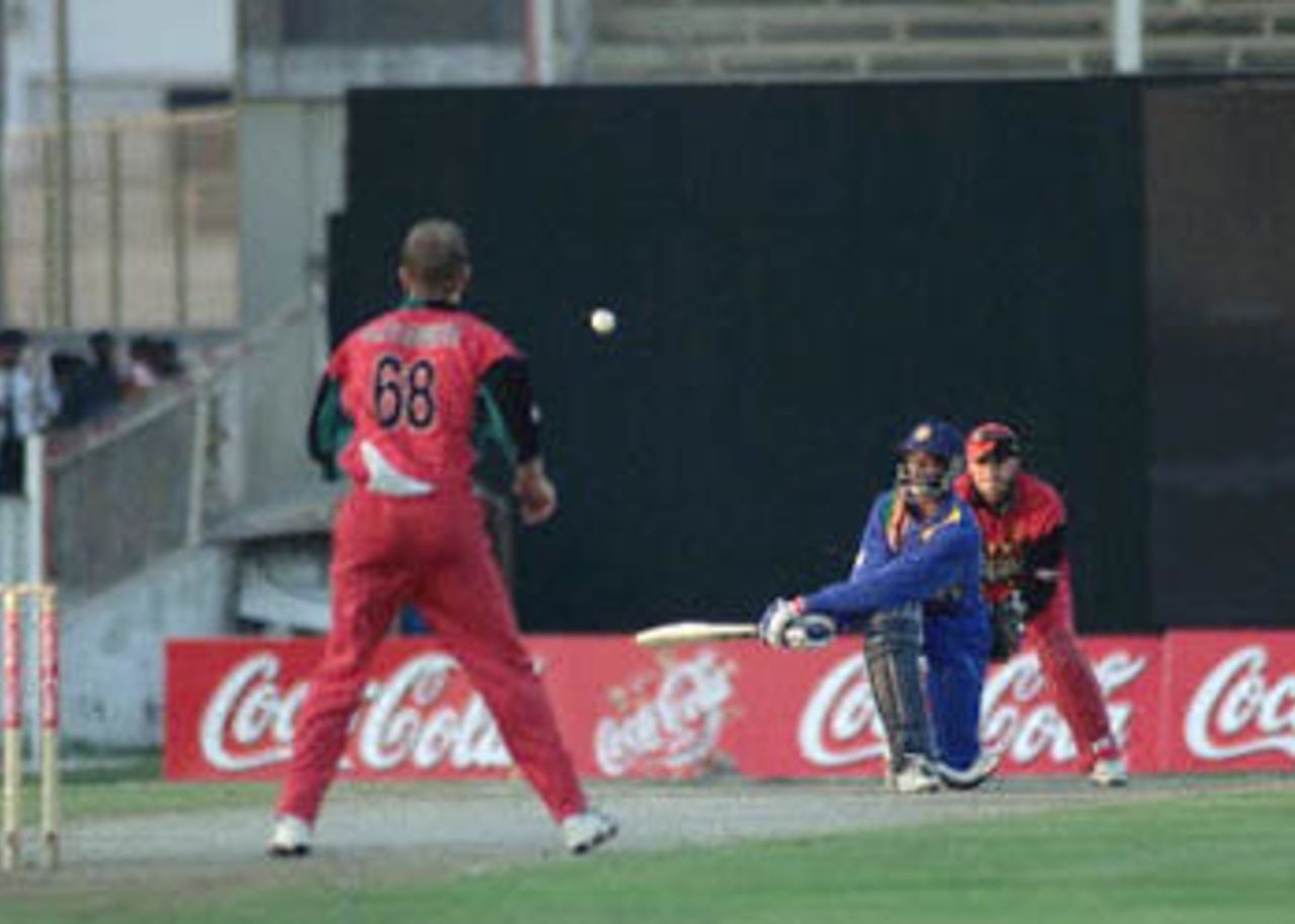 Arnold mistimes a sweep shot against Strang as Flower looks on, Coca-Cola Champions Trophy, 2000/01, 4th Match, Sri Lanka v Zimbabwe, Sharjah C.A. Stadium, 25 October 2000.