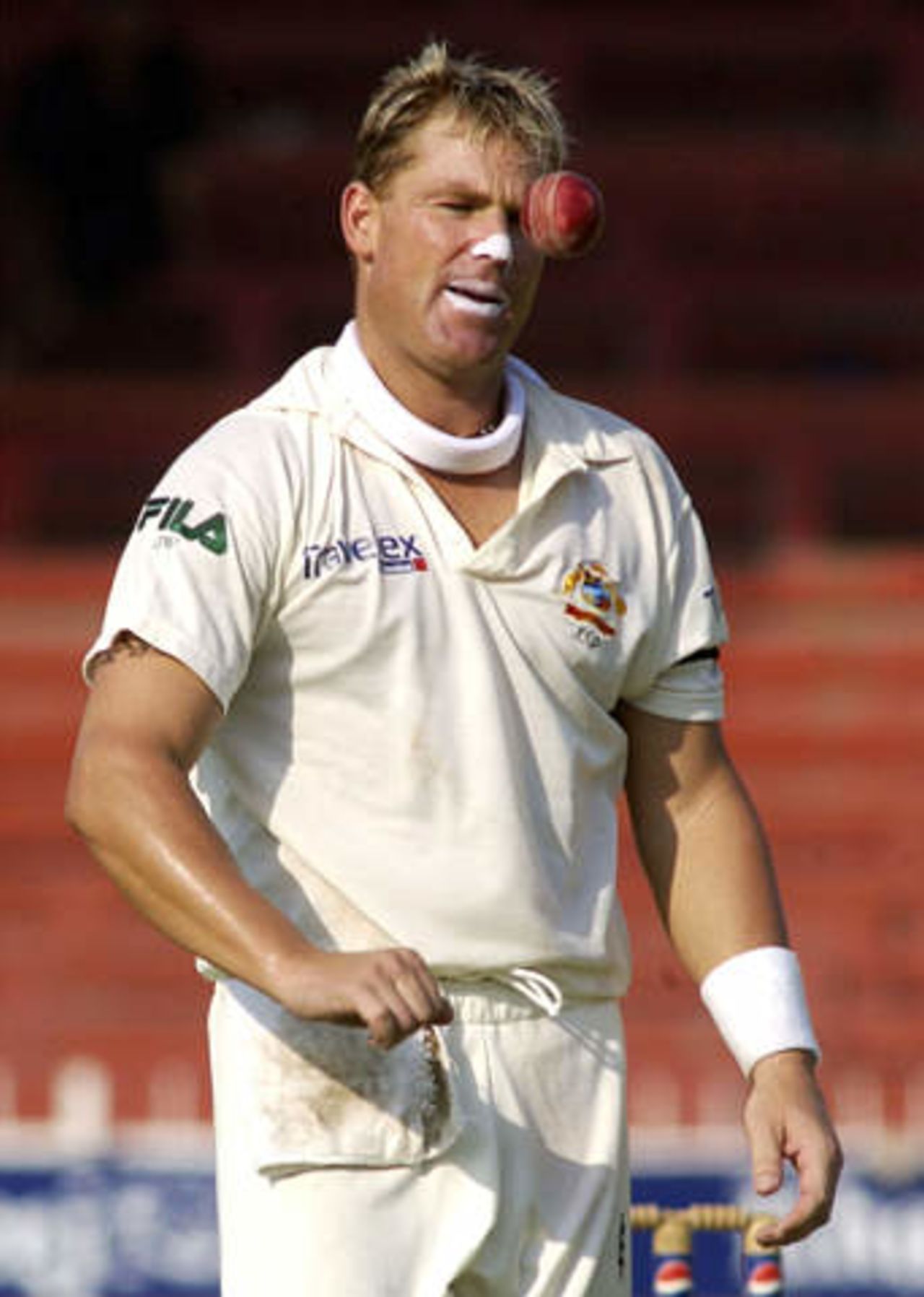 Australian spin bowler Shane Warne tosses the ball in the air before reaching his bowling run up against Pakistan on the second day of the third Test in Sharjah Cricket Stadium October 20, 2002.