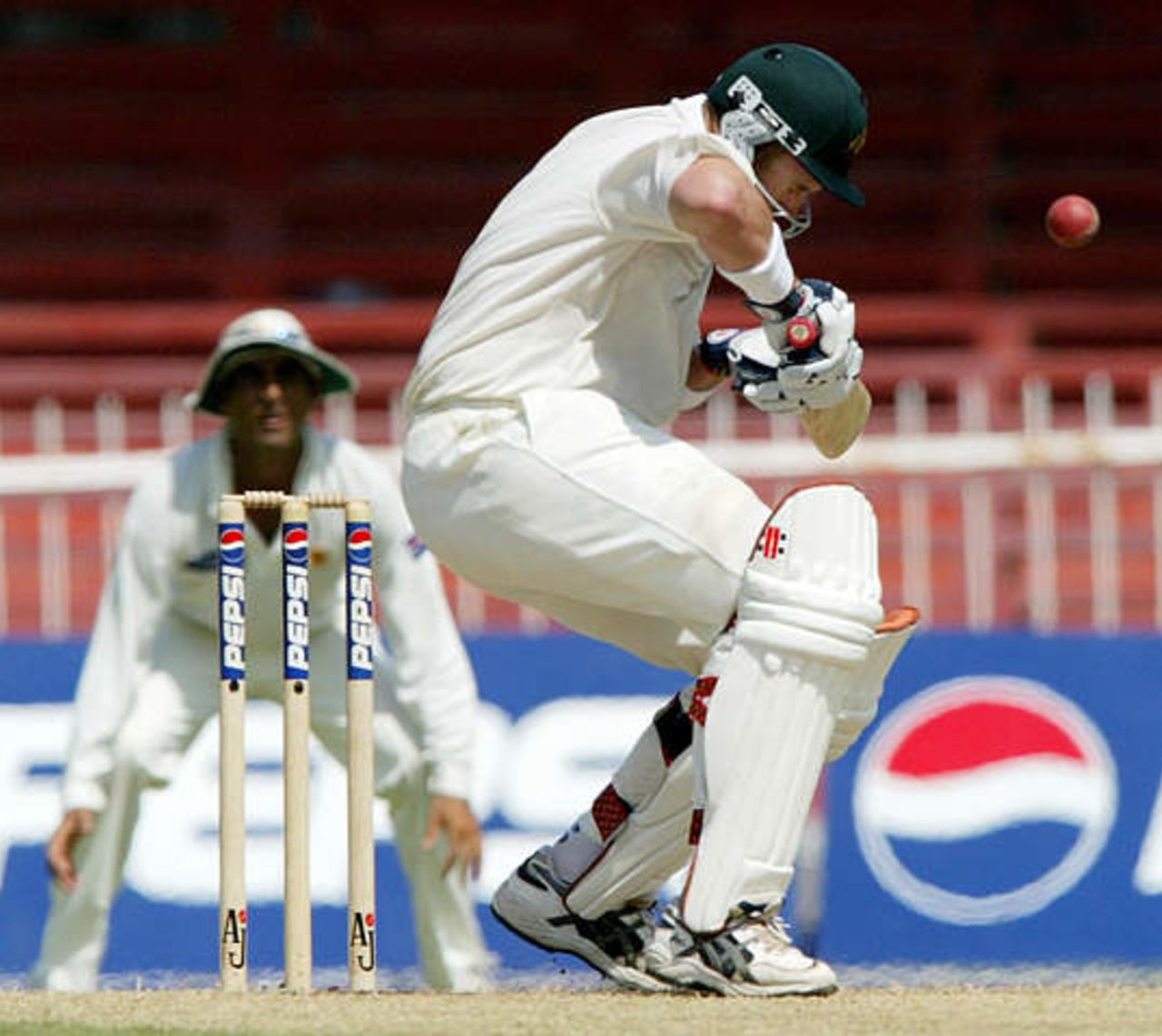Australia's Matthew Hayden braces himself against a ball about to hit his helmet while batting against Pakistan at Sharjah's stadium October 12, 2002 on the second day of their second cricket test match. The second and third tests are being held in the neutral venue of Sharjah after Australia balked at playing in Pakistan due to security concerns.