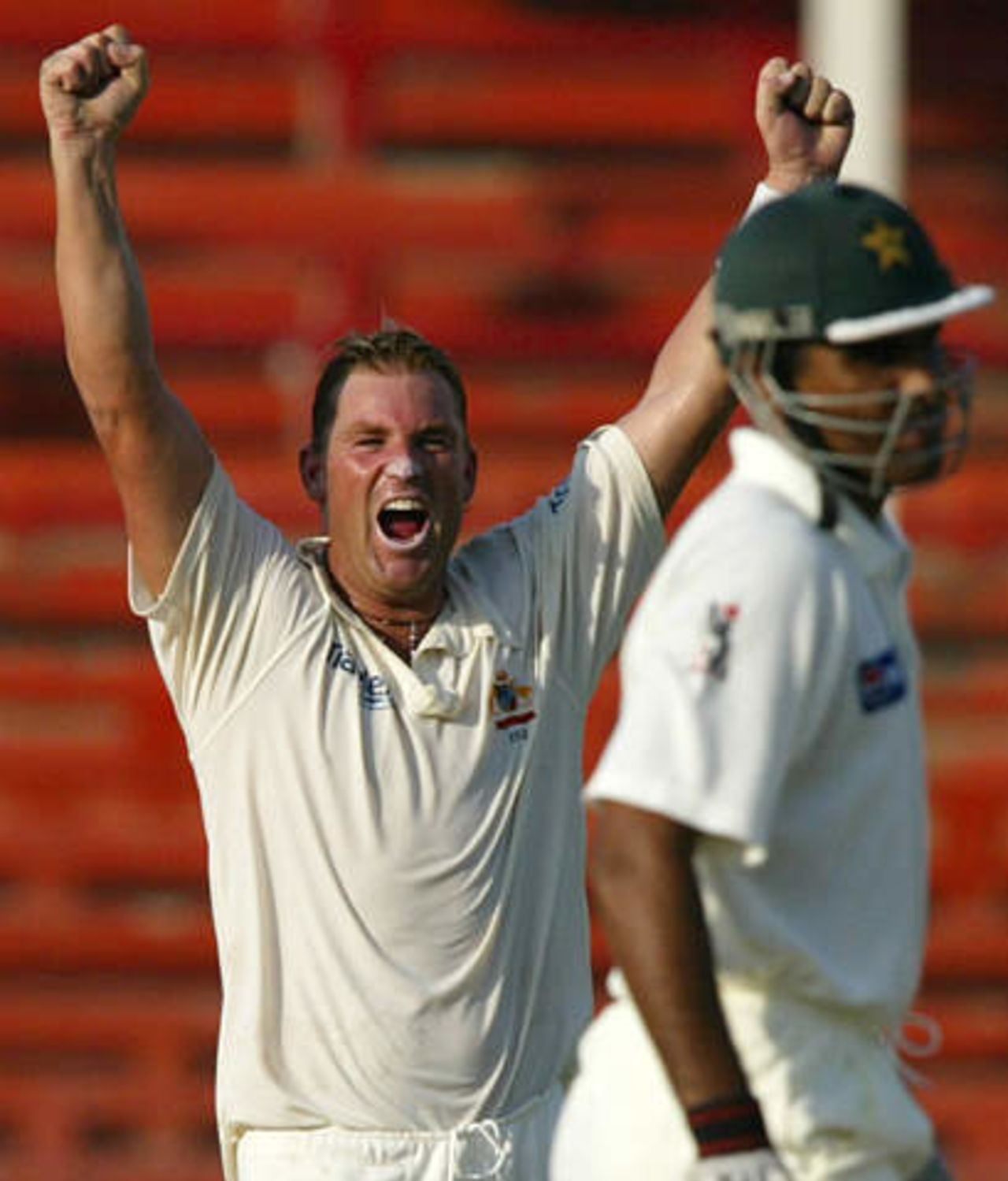 Australian spin bowler Shane Warne celebrates winning his team's second cricket test match after final batsman and Pakistan captain Waqar Younis (L) is dismissed LBW at Sharjah's stadium October 12, 2002. Pakistan crumbled to defeat in less than two days of the second test against Australia on Saturday, adding just 53 to their first innings 59 and losing by an innings and 198 runs.