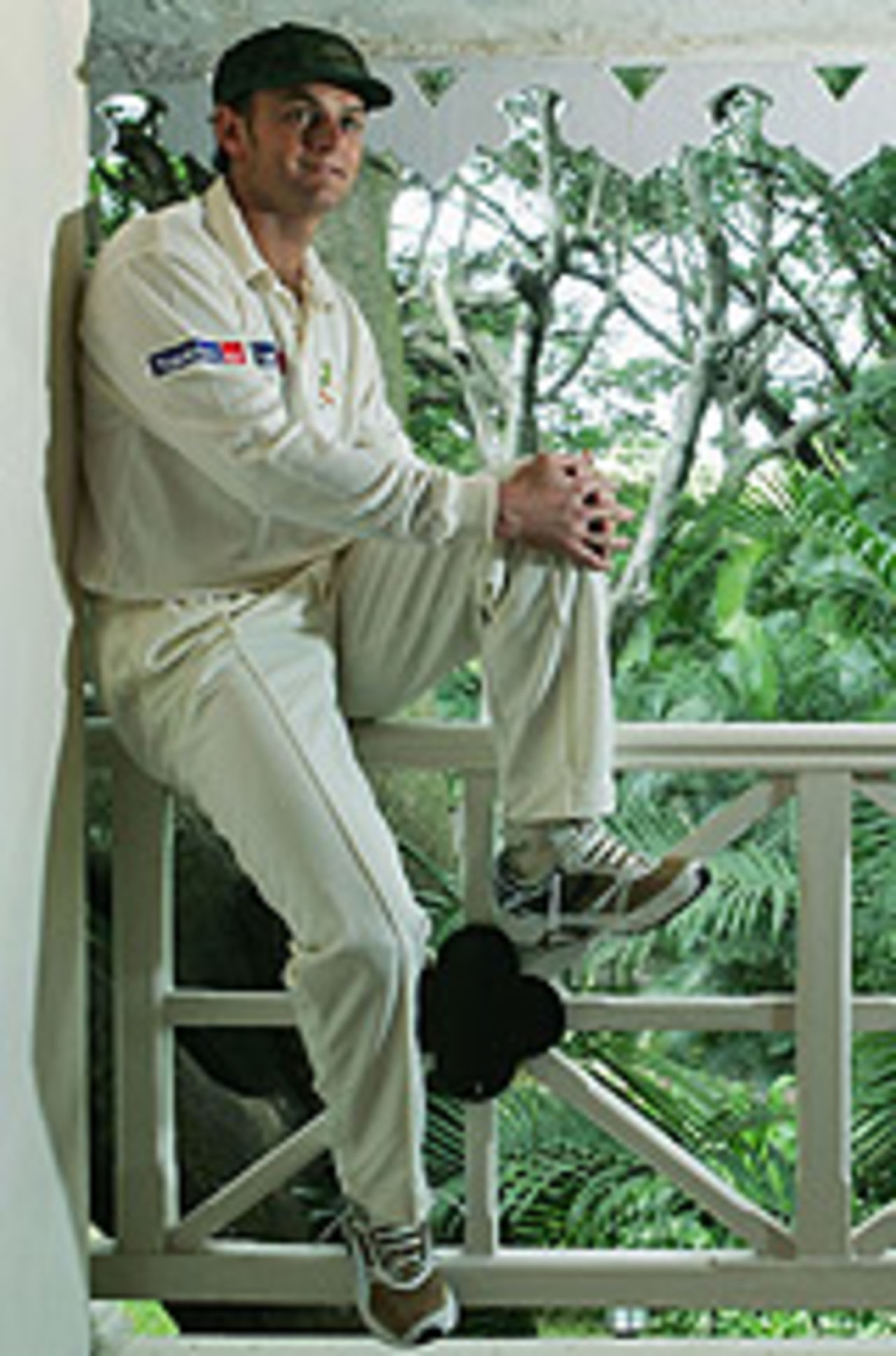 Adam Gilchrist poses on the balcony at the team hotel, as Australia prepare for the first Test against India at Bangalore, October 4, 2004