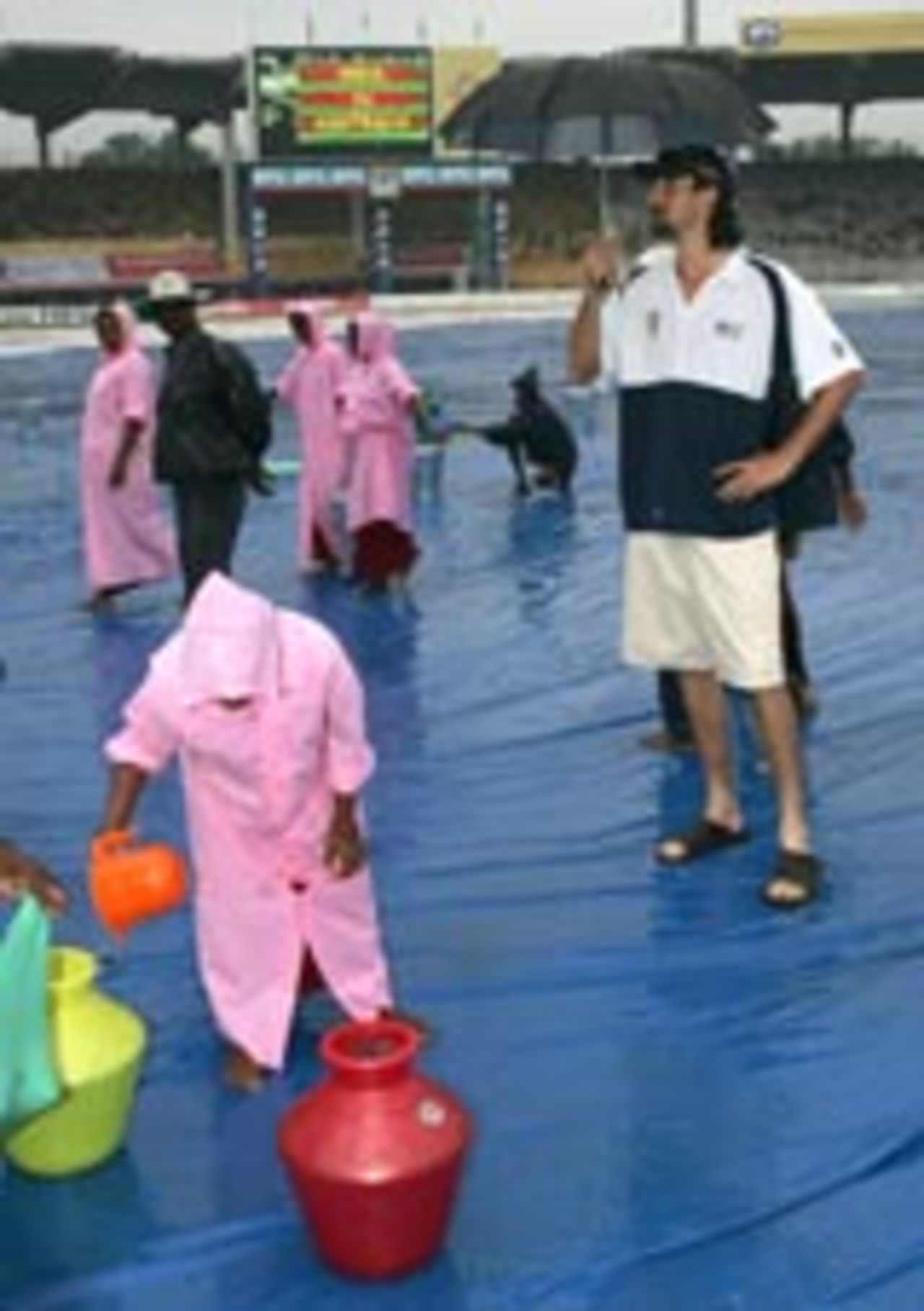 Jason Gillespie with umbrella as mopping-up work continues, India v Australia, 2nd Test, Chennai, 5th day, October 18, 2004