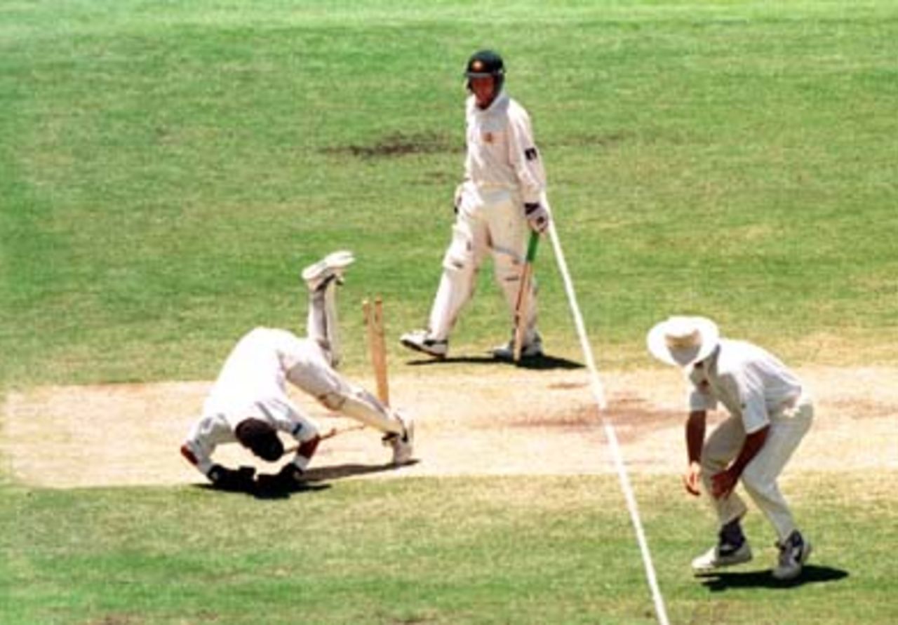 NZ keeper Adam Parore falls onto the stumps after a wayward return throw during the 4th day of the 1st Test between Australia and New Zealand at the Gabba, 7 - 11 Nov 1997