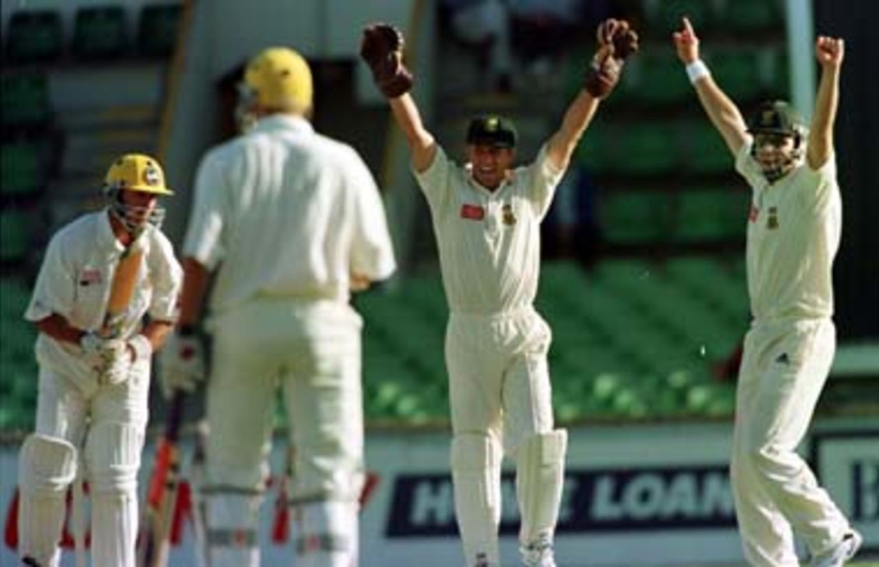 Dave Richardson and Adam Bacher go up in celebration as Rob Baker is caught by Brian McMillan off Pat Symcox for 46, to be the first first class wicket of the tour. South Africa v Western Australia at the WACA, Perth, Day 2, Friday November 28th 1997.