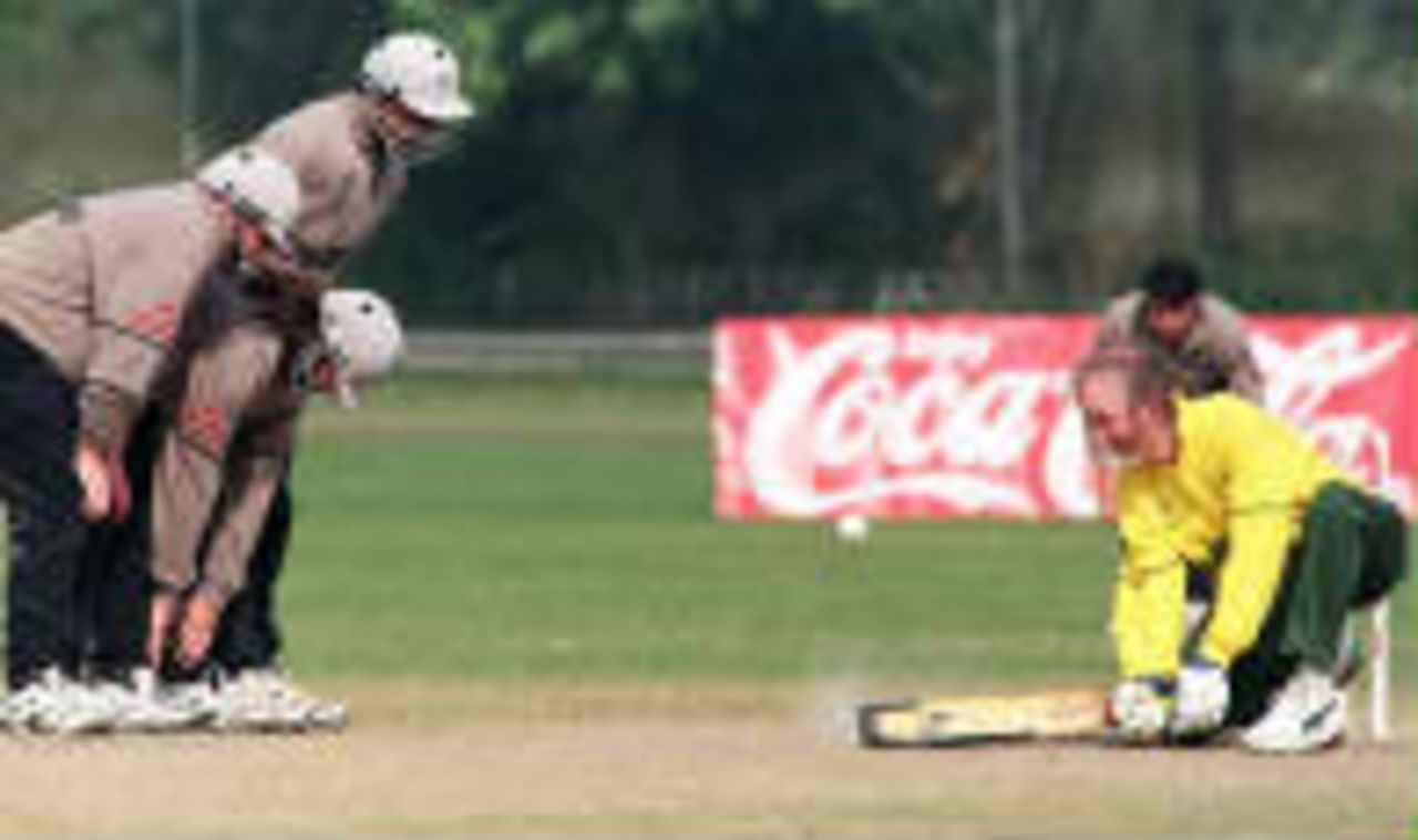 Roger Eagers plays a stroke as blind New Zealand fieldmen stand by ...