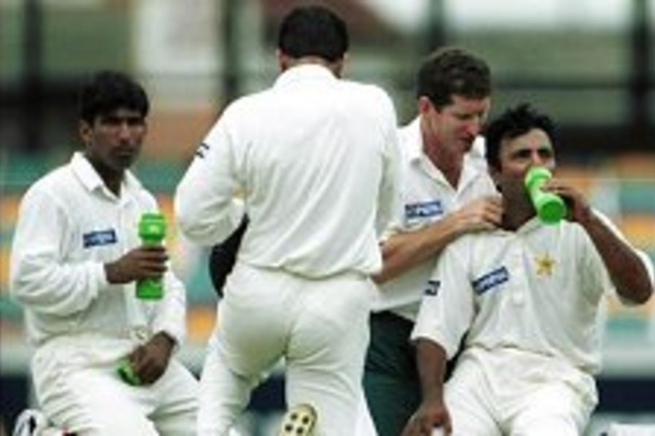 8 Nov 1999: Yousaf Youhana on left who scored 75 and Saeed Anwar who scored 118 not out take a drinks break and recieve physio treatment against Australia during the fourth days play of the First Test match between Australia and Pakistan at The Gabba, Brisbane, Australia