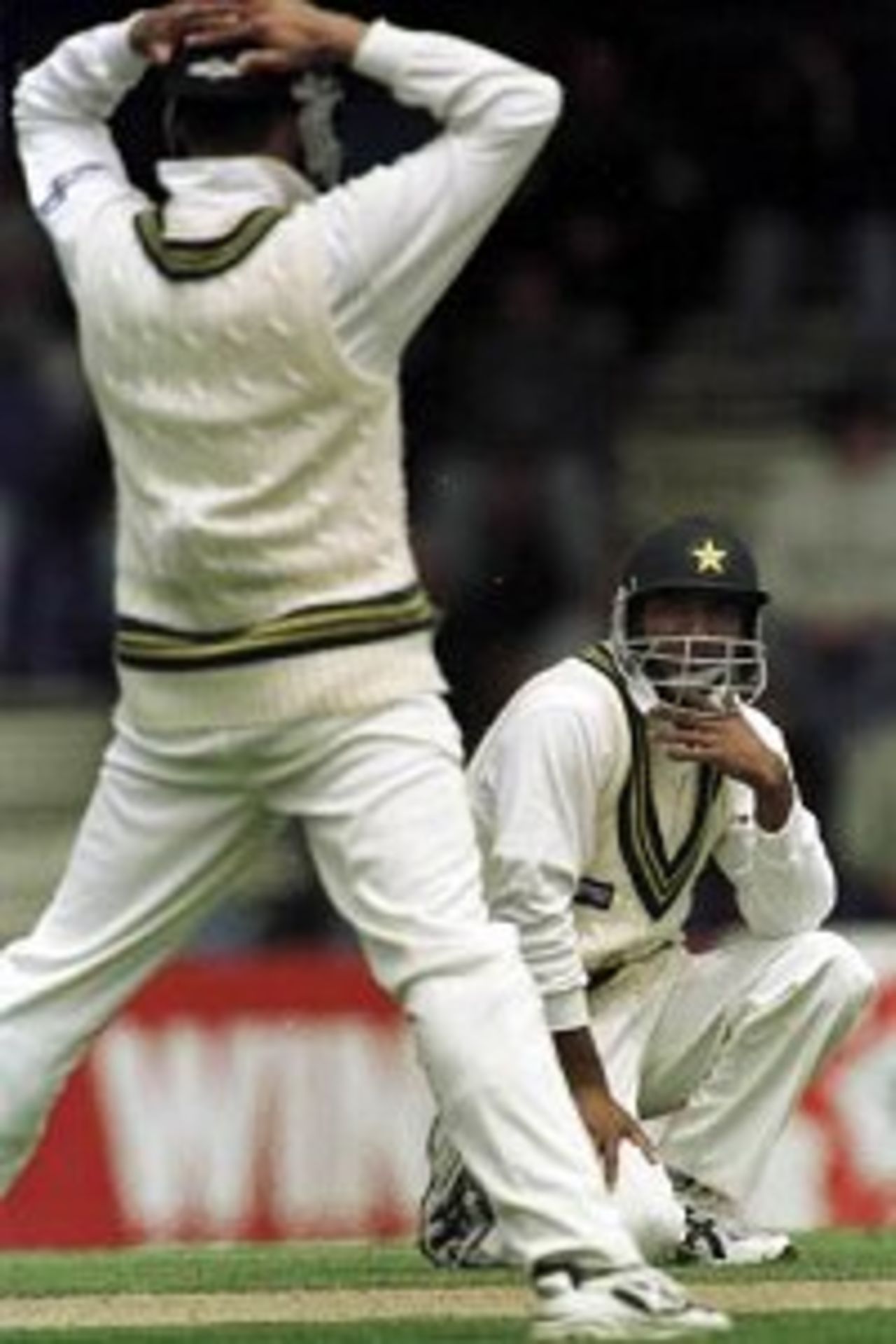 19 Nov 1999: Pakistan fieldsmen Mohammad Wasim and Yousaf Youhana stare at each other in disbelief after a catch off the batting of Australian batsman Michael Slater is dropped, during day two of the Second test between Australia and Pakistan at Bellerive Oval, Hobart, Australia.