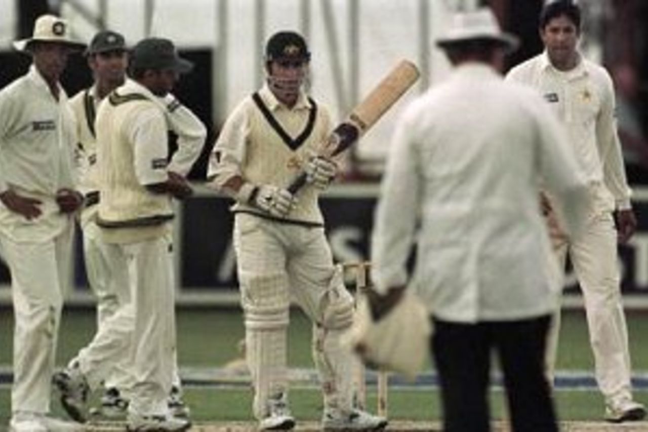 22 Nov 1999: Australian batsman Justin Langer is surrounded by Pakistan players including captain Wasim Akram (fifth from left) after Langer was controversially given not out by umpire Peter Parker, (back to camera) following a delivery from Akram which was caught behind by wicketkeeper Moin Khan. Langer was 76 at the time but went on to score 129, sharing a partnership with Adam Gilchrist of 238 runs, was named man of the match, and secured victory for Australia by four wickets on day five of the Secondtest between Australia and Pakistan at Bellerive Oval, Hobart, Australia.