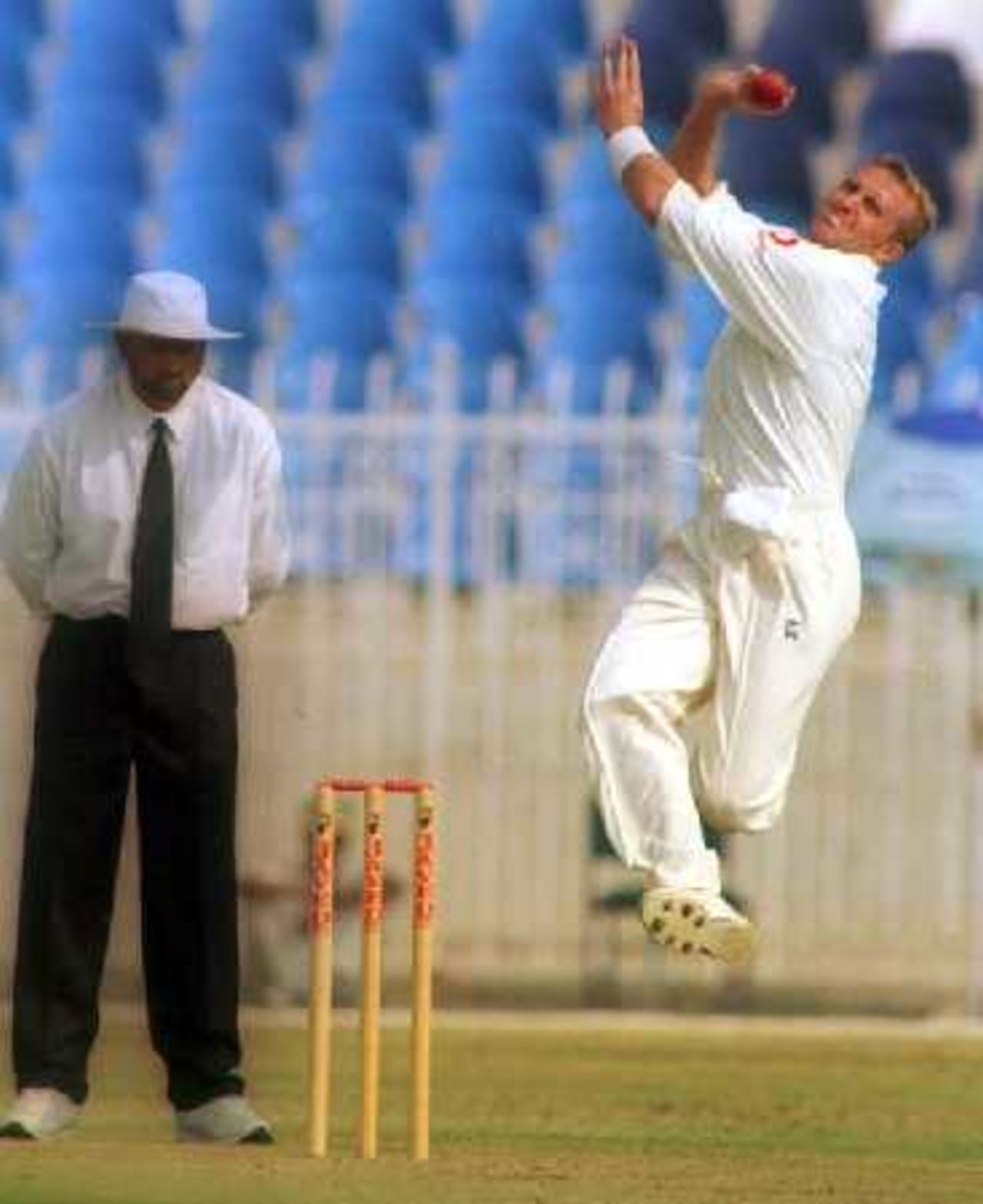 Dominic Cork in action while umpire Kamal Merchant looks on, 4-day match PCB Patrons XI v England XI at Rawalpindi Cricket Stadium, 1-4 November 2000