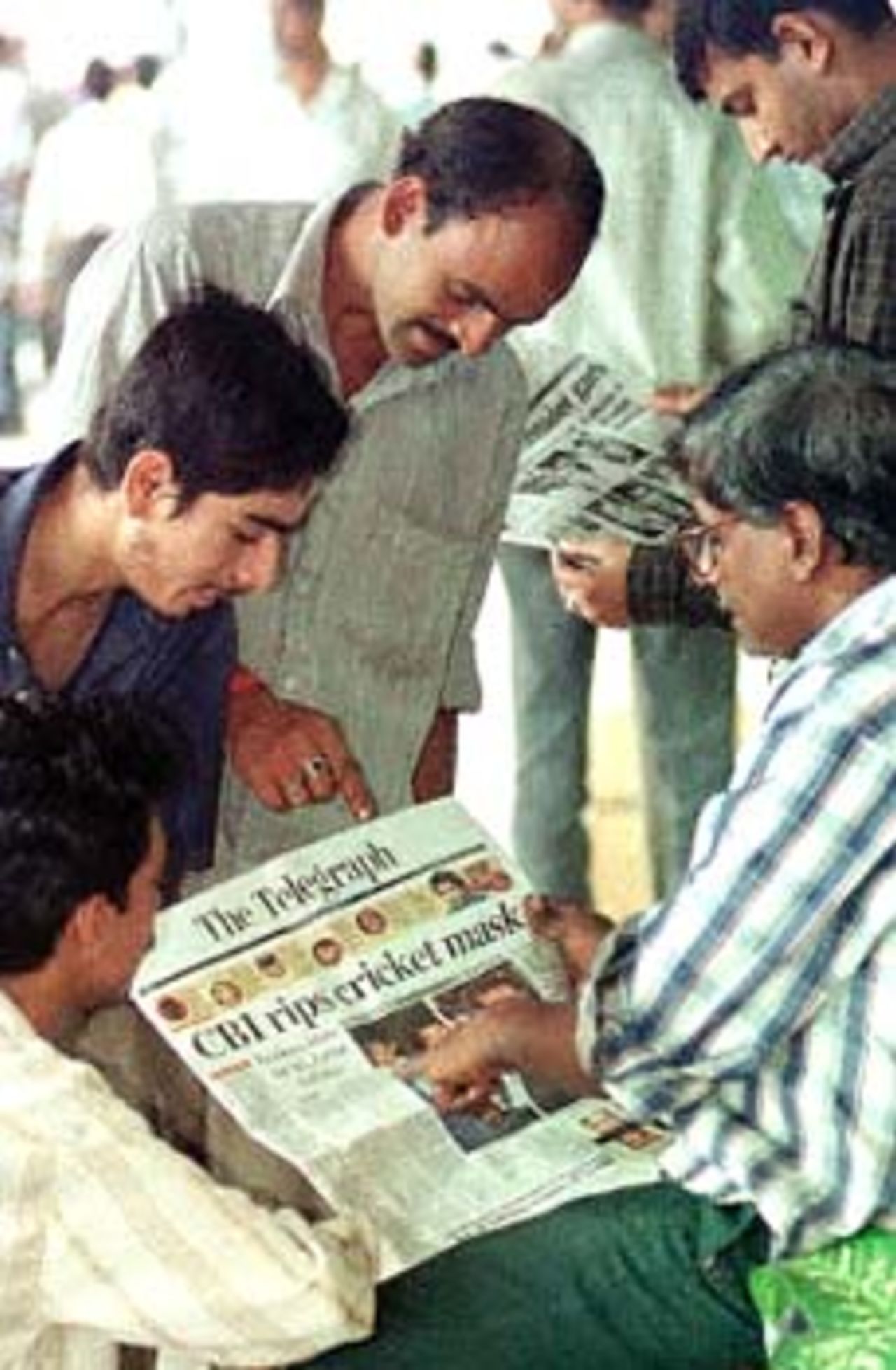 Cricket fans catch up with news on the cricket match fixing scandal at a news stand in Calcutta 02 November 2000. A Central Bureau of Investigation (CBI) report released 01 November named top Indian and international cricket players including former Indian skipper Mohammad Azharuddin, England's Alec Stewart, Brian Lara of the West Indies and others, as being involved in the rigging of international cricket matches for cash.