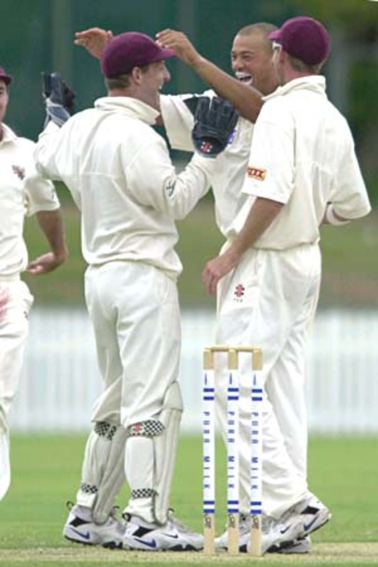 6 Nov 2000: Andy Symonds of Queensland celebrates with team mates Wade Seccombe and Matthew Anderson after getting the wicket of Matthew Mott of Victoria for 31 runs during the Pura Cup match between Queensland and Victoria played at Allan Border Field in Brisbane, Australia.