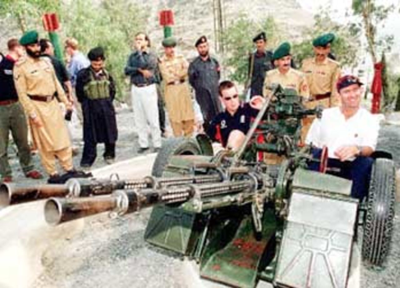 England's cricket players Ashley Giles (2-nd R)) and Andrew Caddick (R) sit on an anti-aircraft cannon during the English's team trip to the Khyber Pass, an historical place on the Pakistan-Afghanistan border, in the country's North West Frontier Provine (NWFP), 06 November 2000. England will play a four-day side match against NWFP Governor's XI on November 08.