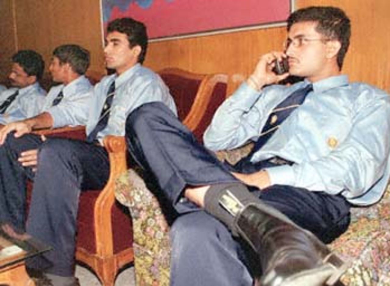 Indian cricket team skipper Sourav Ganguly (R) uses a mobile phone after arriving at Zia International Airport's VIP lounge in Dhaka 07 November 2000. India will play a maiden test against Bangladesh from 10 to 14 November.