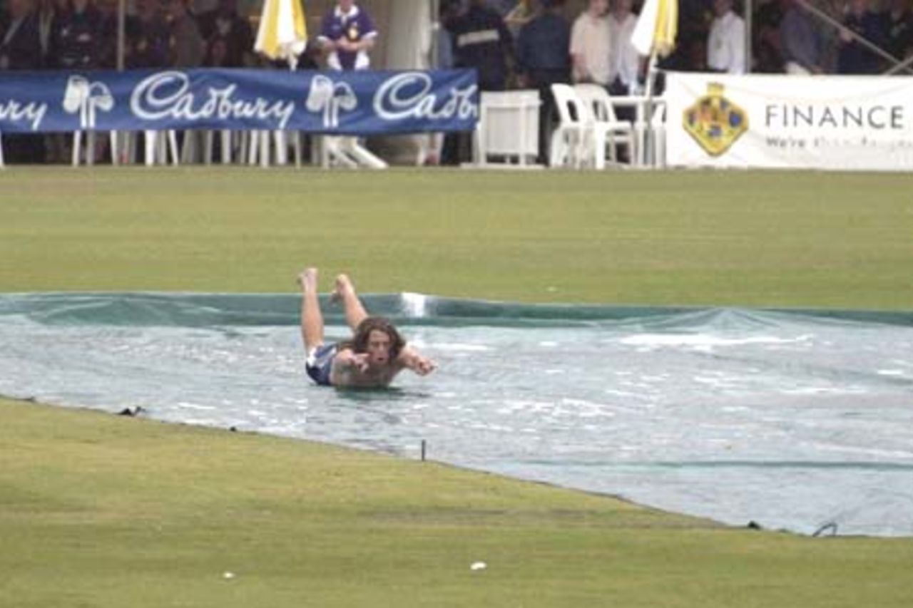 07 Nov 2000: A spectator finds a new use for the covers over the wicket after the the match between the Australian Cricket Board's Chairman's XI and the West Indies is washed out at Lilac Hill in Perth, Australia.