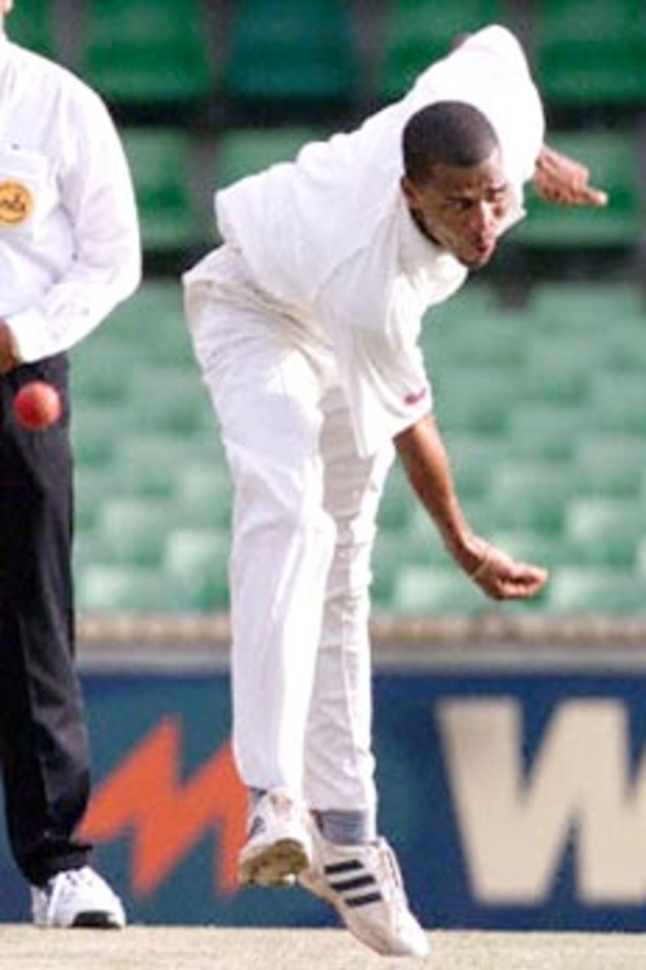 West Indies fast bowler Mervyn Dillon delivers the ball to batsman Mike Hussey from the Western Warriors (a West Australian state side) at the WACA ground in Perth, 09 November 2000. Dillon has taken one wicket for 33 runs off ten overs, as the Western Warriors chase the West Indies first innings total of nine for 132.