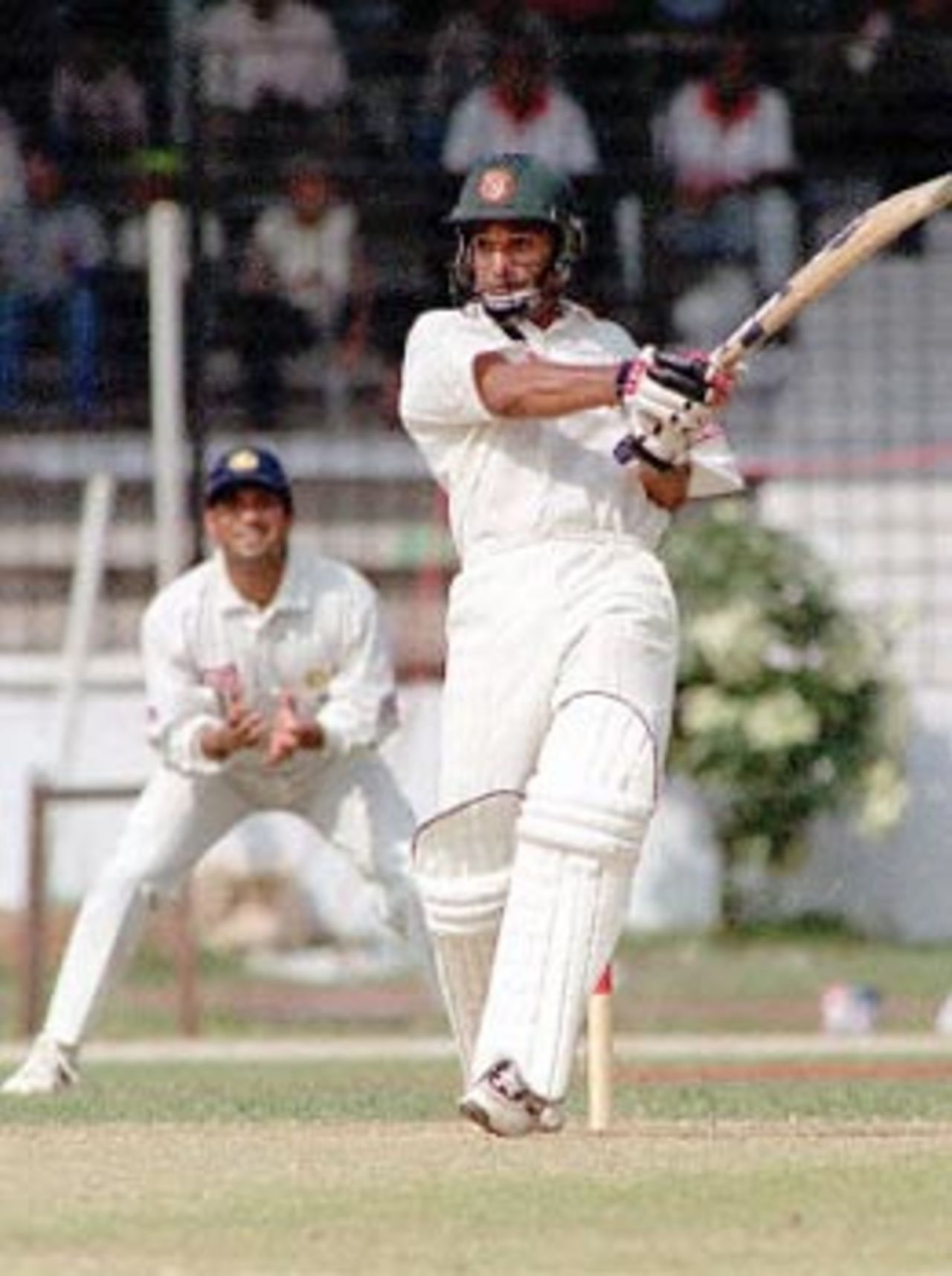 Bangladeshi batsman Habibul Bashar (R), watched by Sachin Tendulker (L), hits a ball off Indian pacer Zahir Khan, 10 November 2000, at Bangabandhu National Stadium during this South Asian country's inaugural Test match against India. Bashar hit 71 before being caught by the Indian skipper Sourav Ganguly off Zaheer Khan. Bangladesh won the toss and elected to bat.