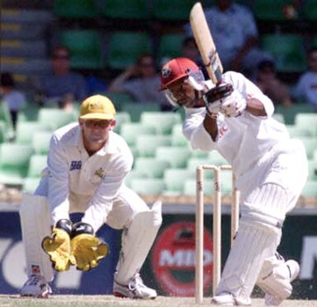 West Indies batsman and vice-captain Sherwin Campbell (R) plays a drive, watched by wicketkeeper Adam Gilchrist (L) during a four day match against the Western Warriors at the WACA ground in Perth 11 November 2000. Campbell is currently 82 not out, with the West Indies 4-181 at tea.