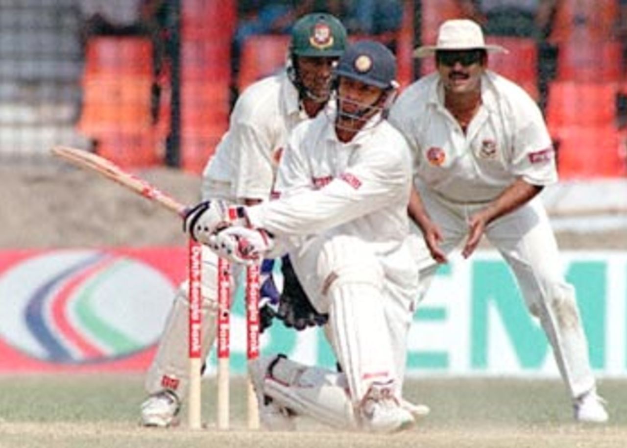 Indian batsman Murli Kratick (C) hits a ball off Bangladeshi skipper Naimur Rhaman (not in the picture) as wicketkeeper Shariar Hossain (L) and Akram Khan (R) look on 12 November 2000 at the Bangabandhu National Stadium on the third day of this South Asian country's inaugural Test match against India. Murli scored 43 before he caught out by Naimur.