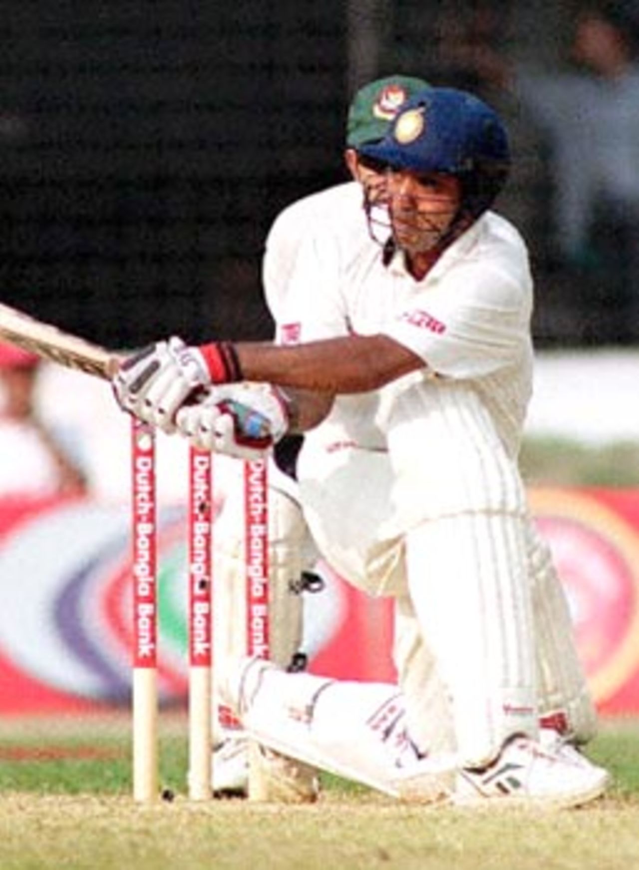 Indian batsman Sunil Joshi (R front) hits a ball off Bangladeshi skipper Naimur Rhaman (not in the picture) 12 November 2000 at the Bangabandhu National Stadium on the third day of this South Asian country's inaugural Test match against India. Sunil hit 71 runs being not out as India scored 366 for 7 wickets after the third day's play.