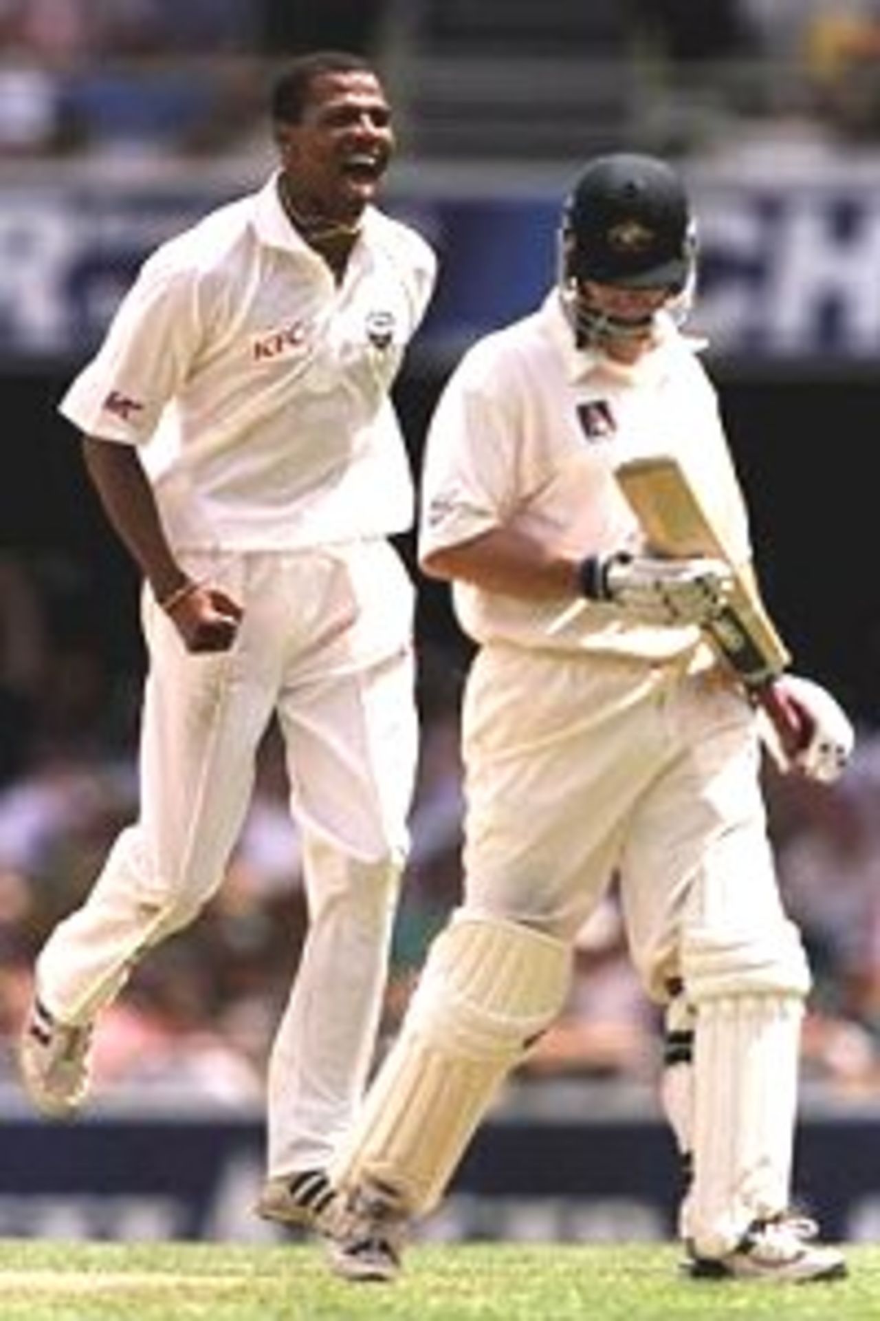 24 Nov 2000: Mervyn Dillon of West Indies celebrates the wicket of Captain of Australia Steve Waugh caught by Sherwin Campbell for 41 during the second day of the First Test match between Australia and West Indies at The Gabba cricket ground in Brisbane, Australia.