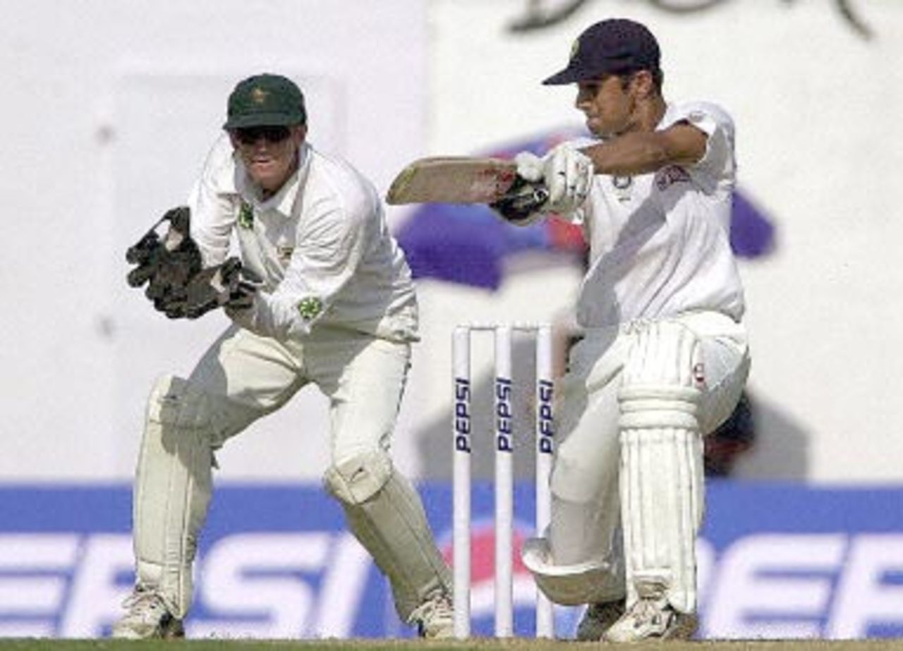 Indian batsman Rahul Dravid hits a ball to the boundary on his way to scoring 93 runs not out as wicketkeeper Andy Flower (L) looks on during the first day of the second Test cricket match between India and Zimbabwe in Nagpur, 25 November 2000. India made 306 for 2 at close of the first day's play. India leads Zimbabwe 1-0 in the two Test series.
