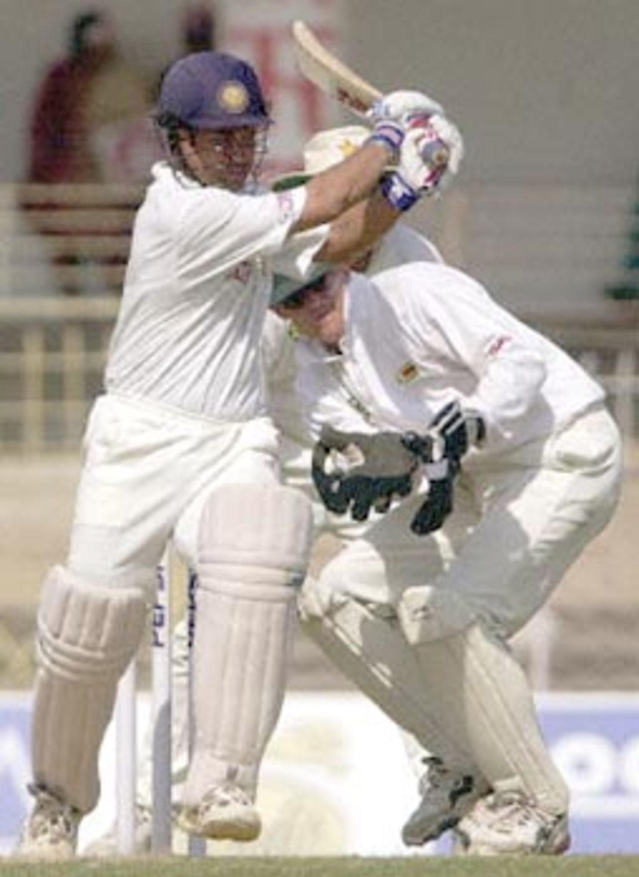 Indian batsman Sachin Tendulkar pulls a delivery from Zimbabwean spinner Brian Murphy (not in picture) as Zimbabwe wicket keeper Andy Flower (R) looks on during the second day of the second test match between India and Zimbabwe 26 November 2000 in Nagpur. Tendulkar was unbeaten on 142 runs by lunch.