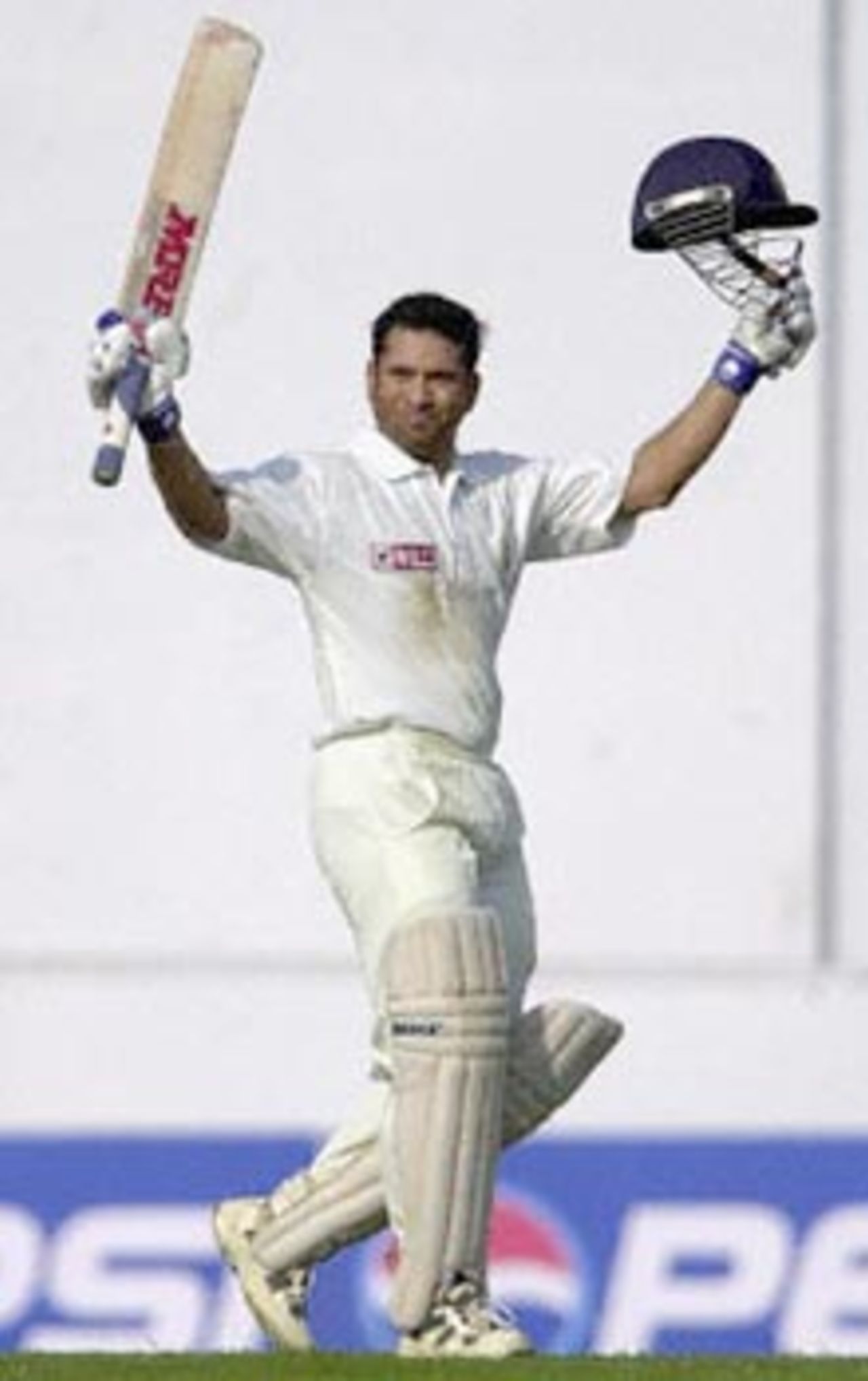 Indian ace batsman Sachin Tendulkar raises his bat and helmet to acknowledge the cheering crowd after scoring a double century on the second day of the second Test match between India and Zimbabwe, 26 November 2000 in Nagpur. Sachin Tenulkar remained unbeaten on 201 as India declared at 609 runs for six wickets.