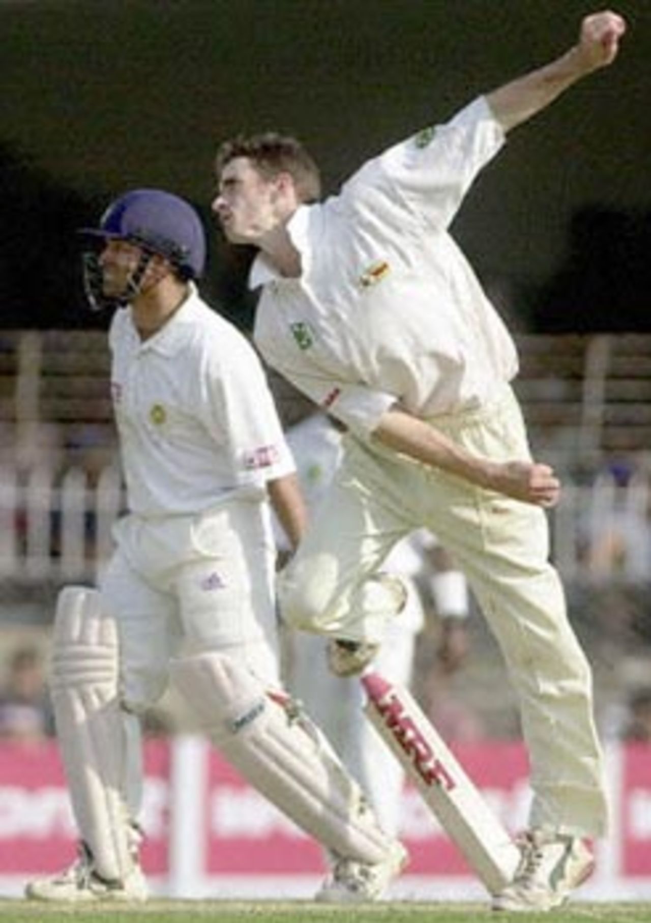 Zimbabwean spinner Brian Murphy bowls to Indian batsman Sunil Joshi as Indian batsman Sachin Tendulkar (L, behind) on the non-strikers end looks on during the second day of the second Test match between India and Zimbabwe, 26 November 2000 in Nagpur . Murphy took two wickets for Zimbabwe to be the highest wicket taker for his team along with team-mate Grant Flower. Zimbabwe finished the day at 59 for 1 in reply to India's total of 609.