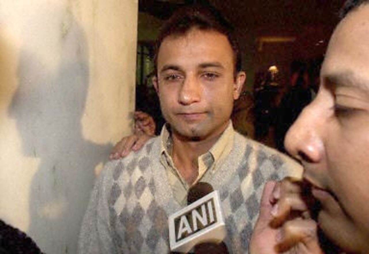 Indian cricket player Nayan Mongia (C) is escorted by a security officer (R) as he makes his way through the lobby of the Taj Man Singh hotel for a last hearing by cricket board officials in New Delhi, 28 November 2000. Mongia, along with former skipper Mohhammad Azharuddin, faces a possible life ban for match fixing.