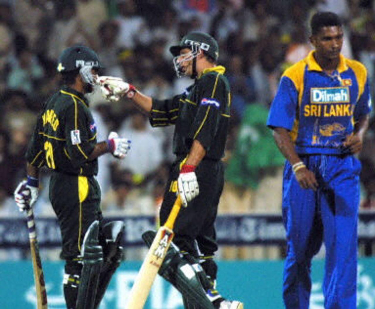 Pakistanis Shahid Afridi and Naved Latif congratulate each other during a cricket match against Sri Lanka in the Three Nation Champion Trophy in Sharjah 04 November