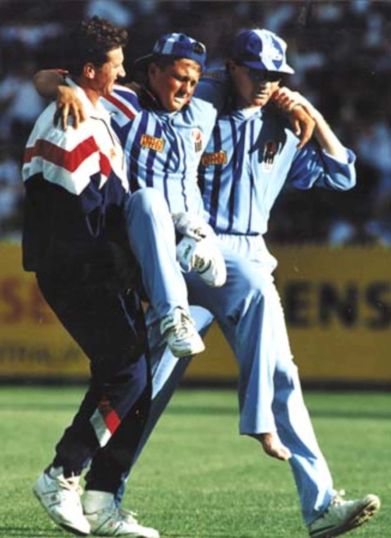 Shaun Udal is on hand to assist Darren Gough off the field in the One Day International at Melbourne in January 1995. Physio Dave Roberts is the other helper.