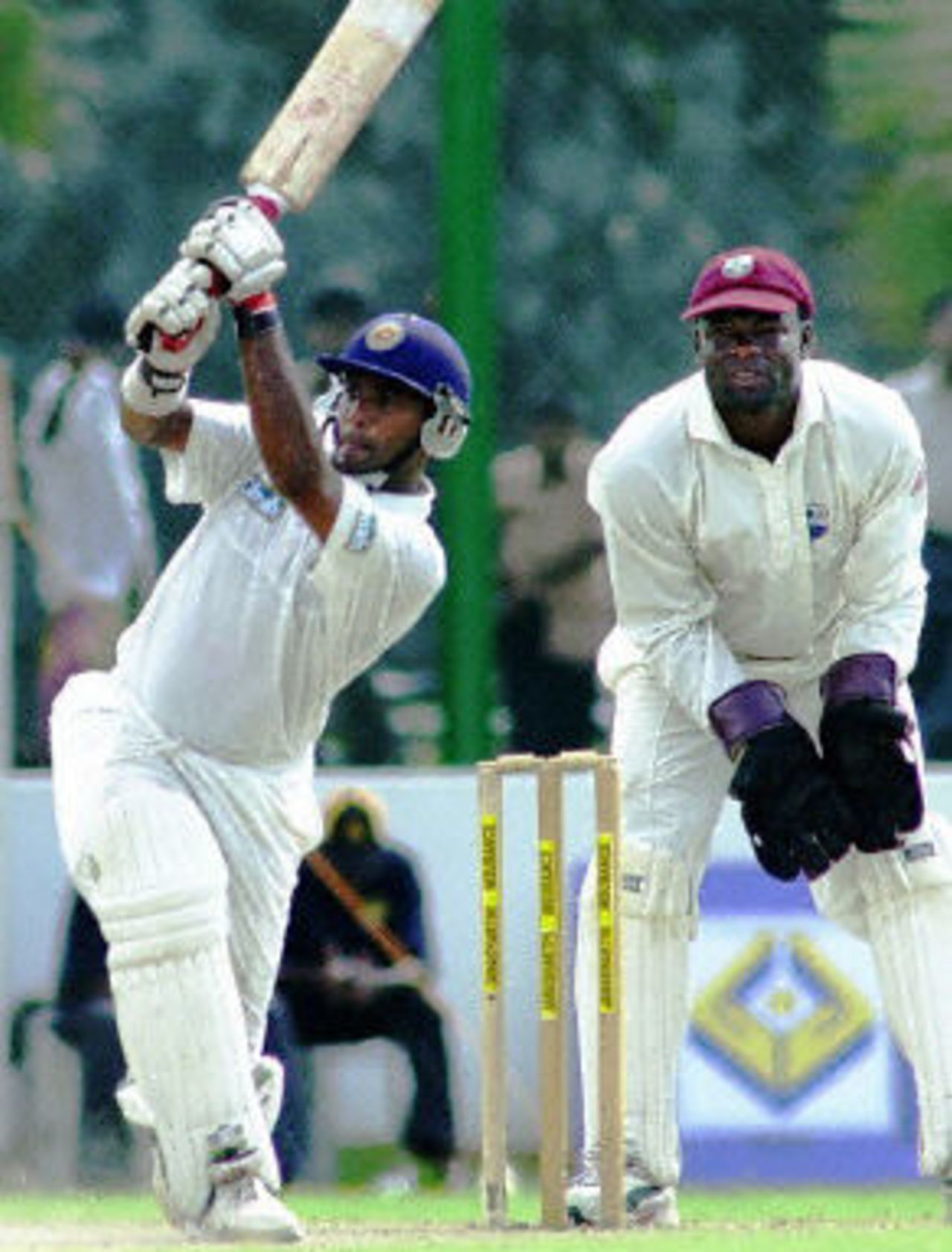 Hashan Thilakaratne drives a ball to the boundary as West Indies wicketkeeper Ridley Jacobs looks on