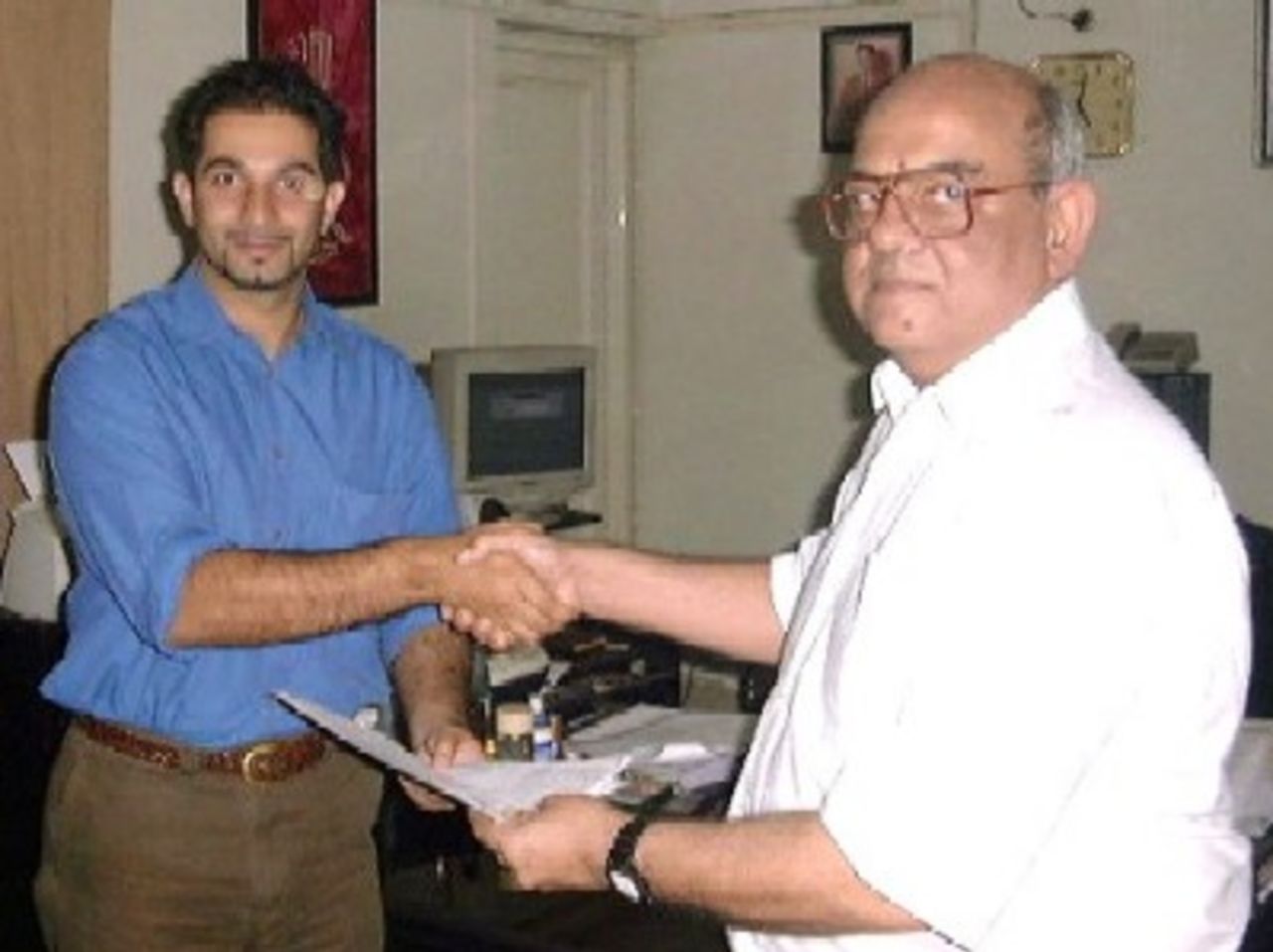 Pakistan domestic cricket contract being exchanged: Left, Mr Faisal Farooq, CEO Anmol Company (Nirala Sweets) and Right, Suhael Ahmed CricInfo Ltd, Pakistan